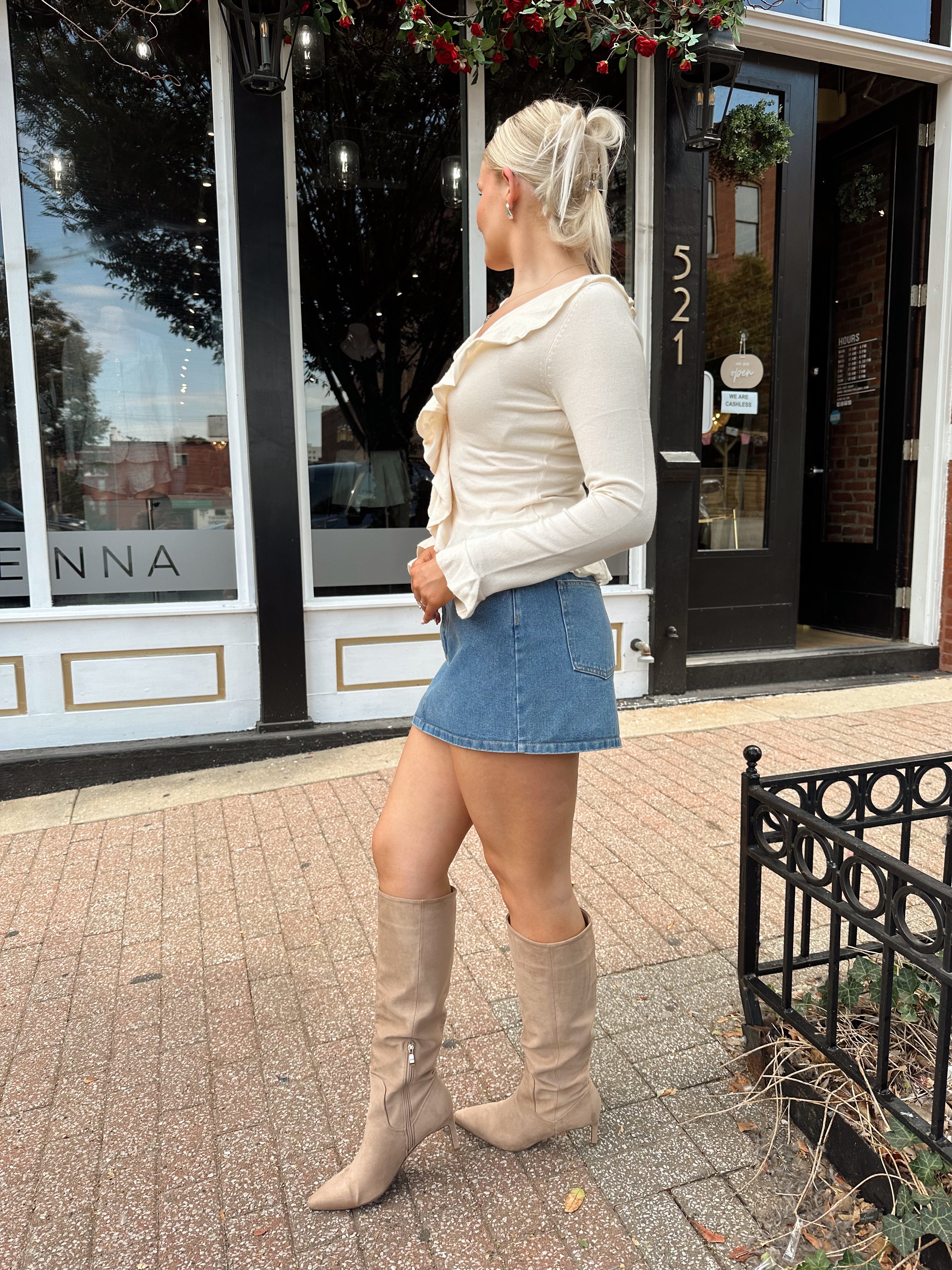 Cream colored knit long sleeve top with button detailing and ruffle neckline