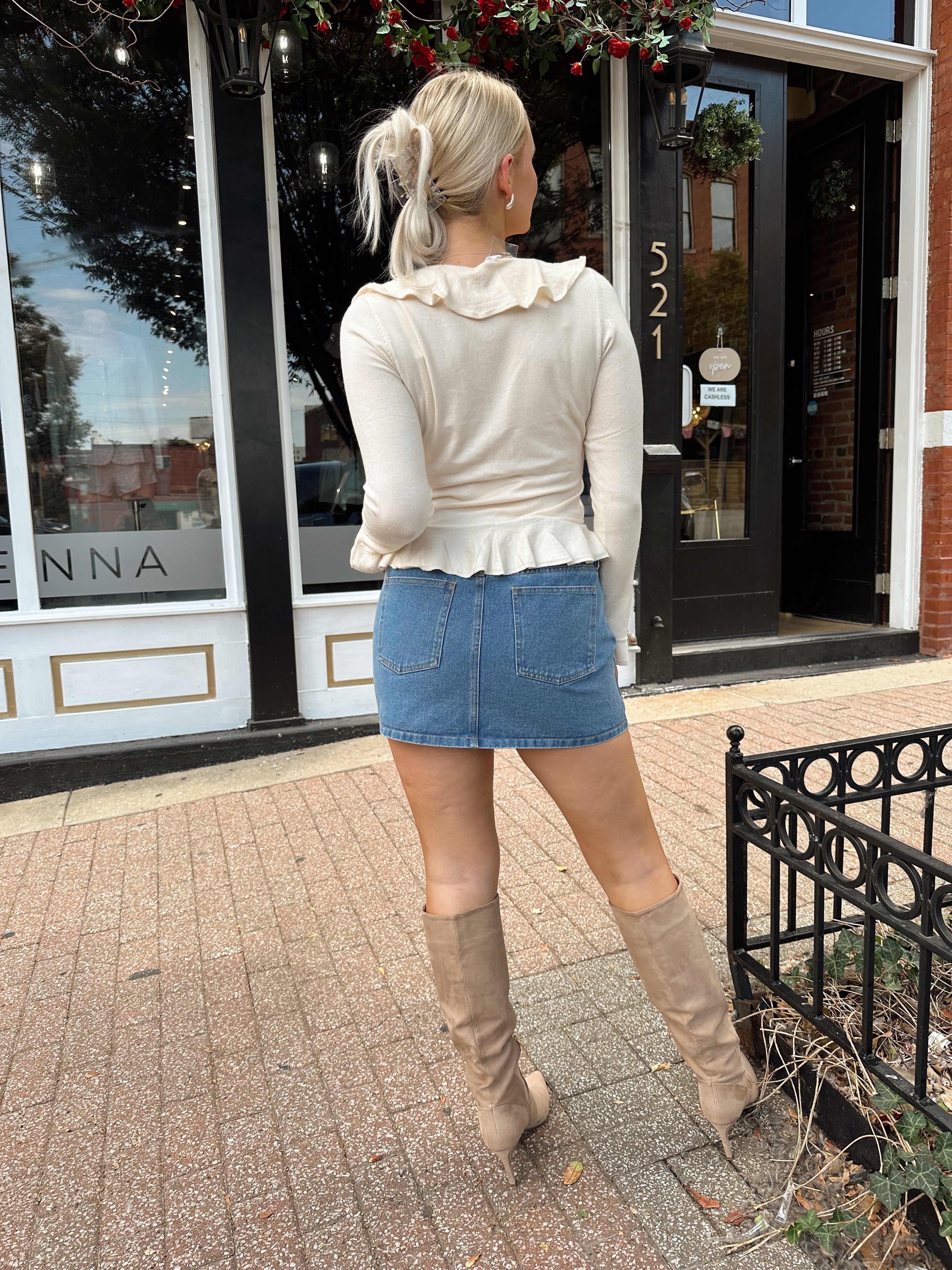 Cream colored knit long sleeve top with button detailing and ruffle neckline