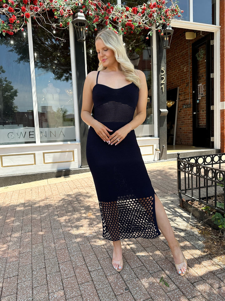 Woman wearing navy blue knit midi dress with netting bottom and adjustable straps. 