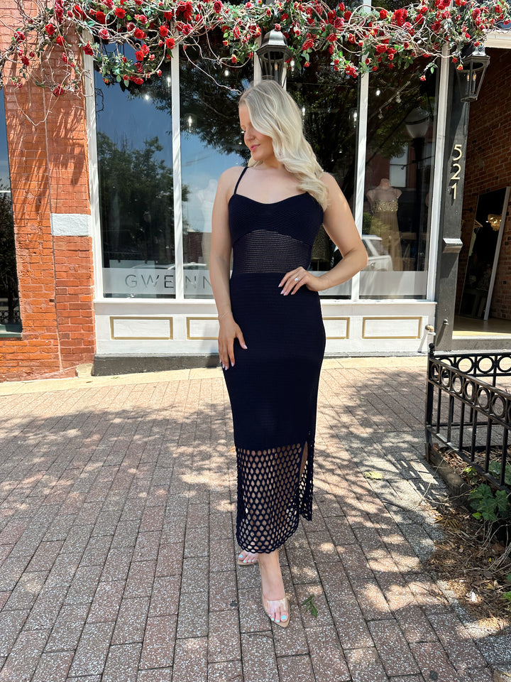 Woman wearing navy blue knit midi dress with netting bottom and adjustable straps. 