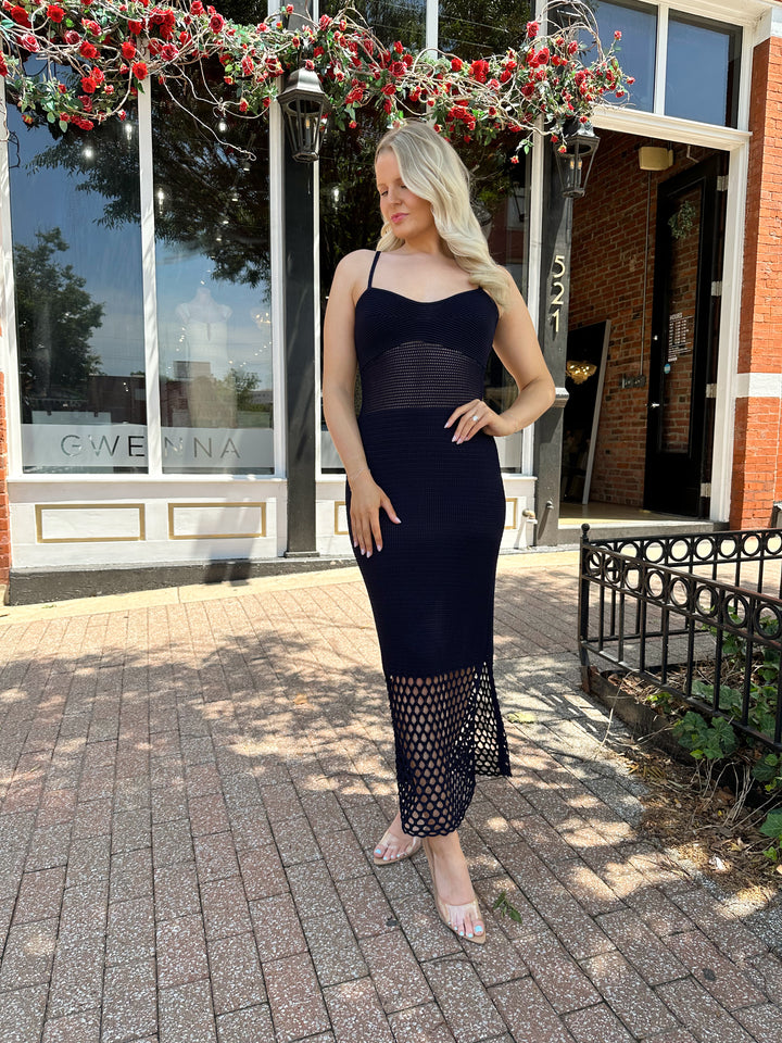 Woman wearing navy blue knit midi dress with netting bottom and adjustable straps. 