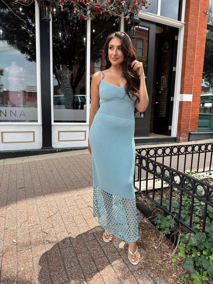 Woman wearing seafoam blue knit midi dress with netting detailing. 