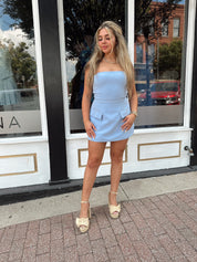 Sky blue tailored strapless mini dress with built in shorts and faux pockets.