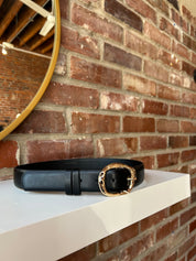 Black leather belt with gold hardware buckle.