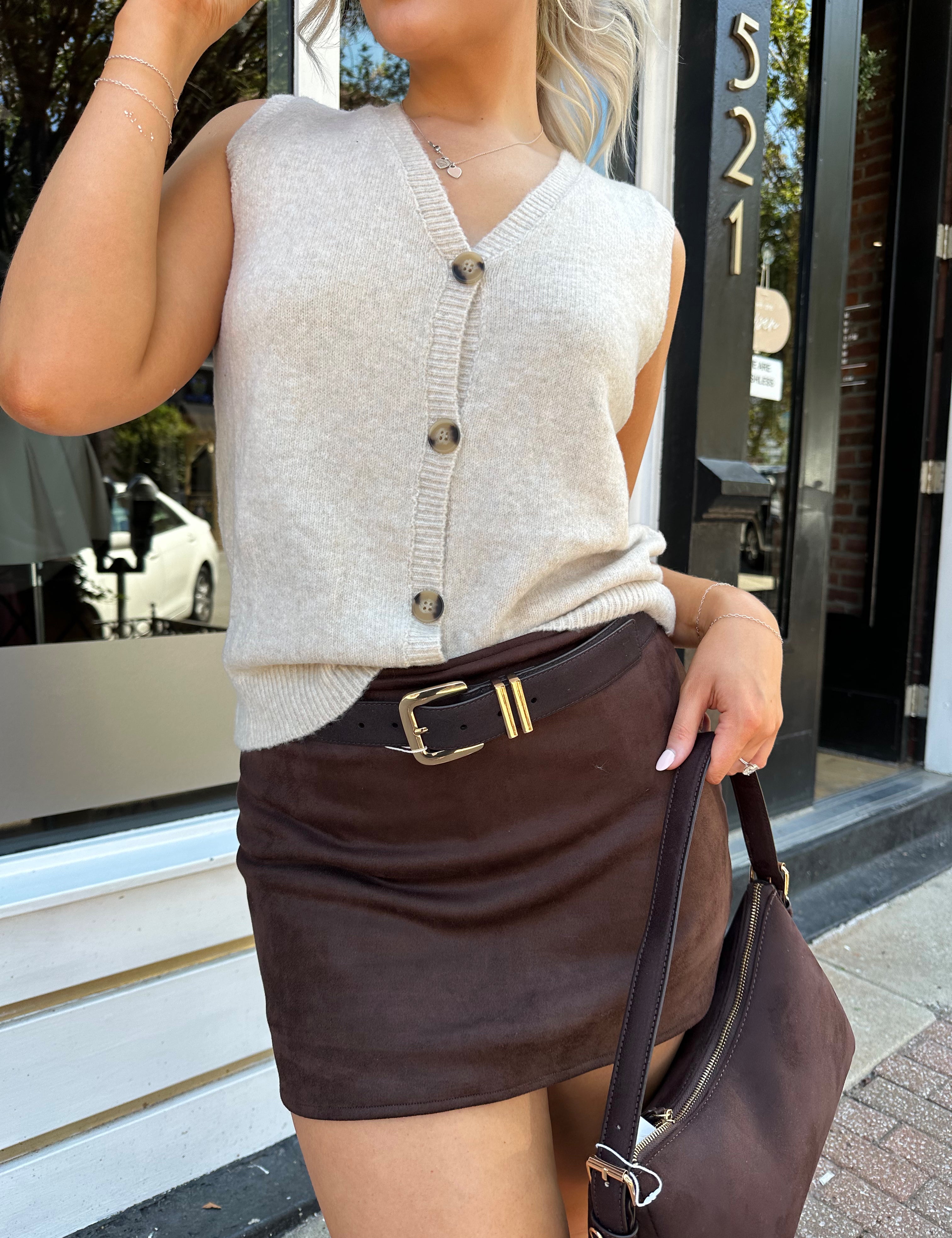 Woman wearing dark brown suede mini skirt with built in shorts. 
