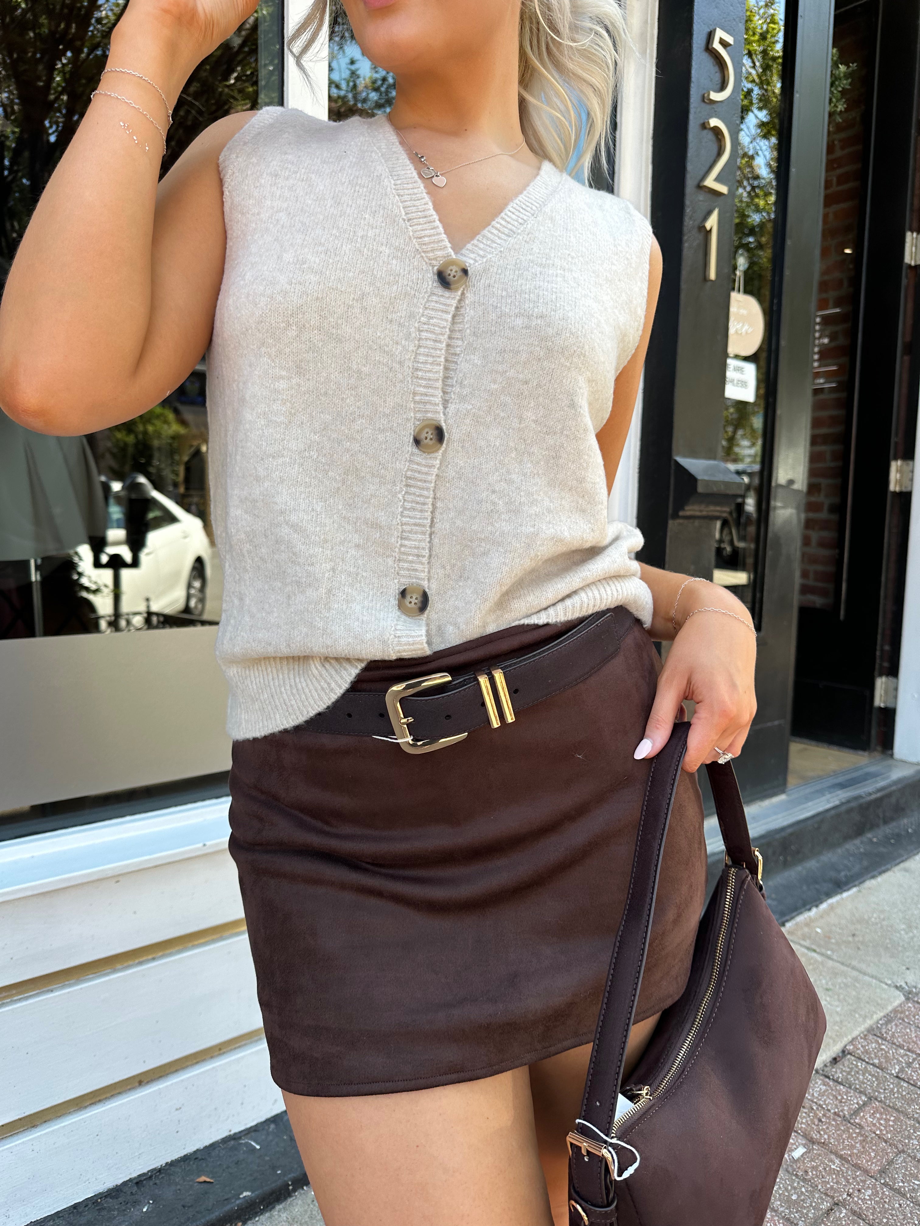 Woman wearing dark brown suede mini skirt with built in shorts. 