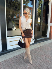 Woman wearing dark brown suede mini skirt with built in shorts. 