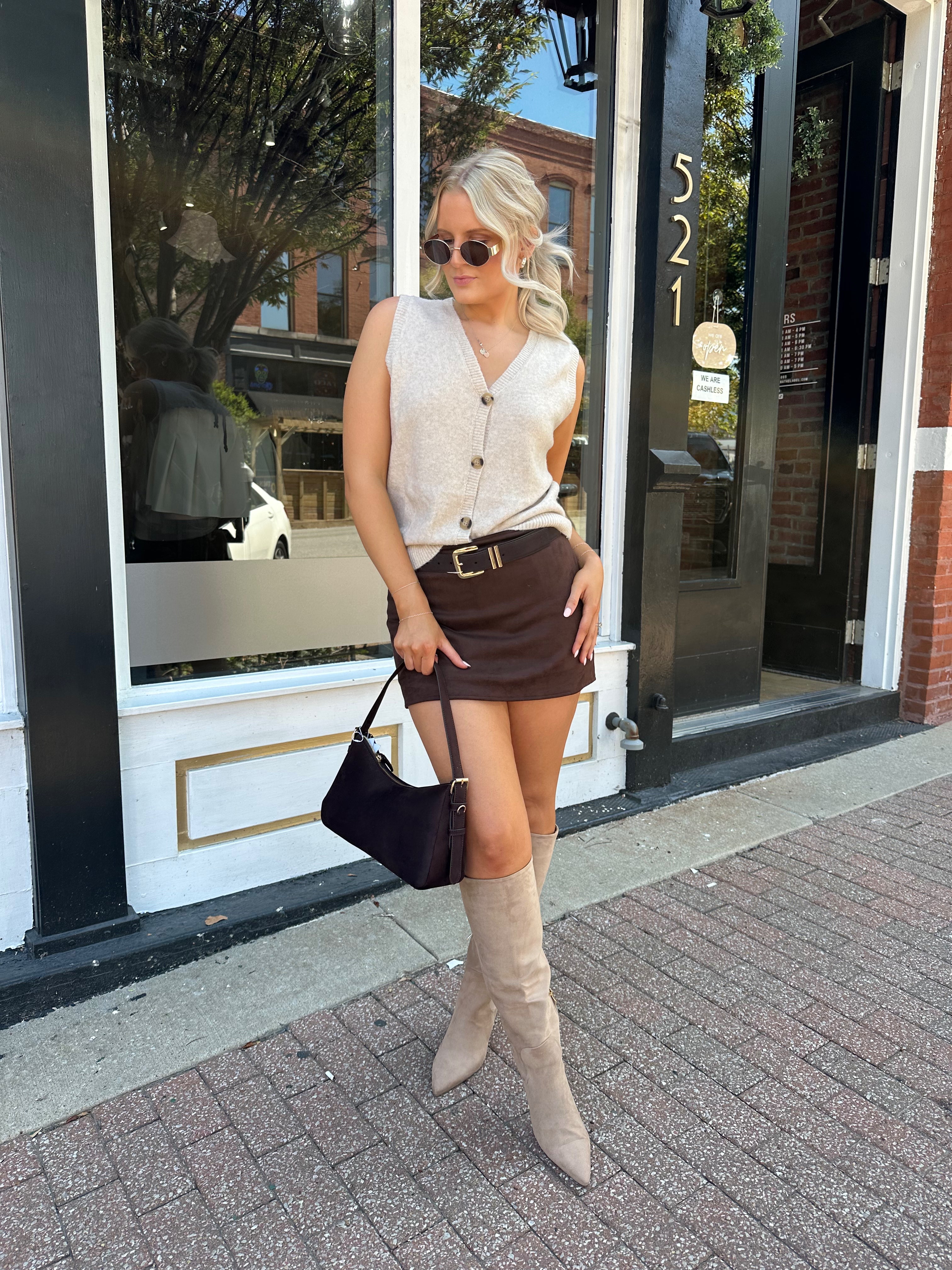 Woman wearing dark brown suede mini skirt with built in shorts. 
