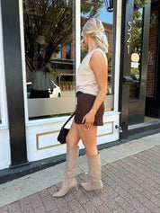 Woman wearing dark brown suede mini skirt with built in shorts. 