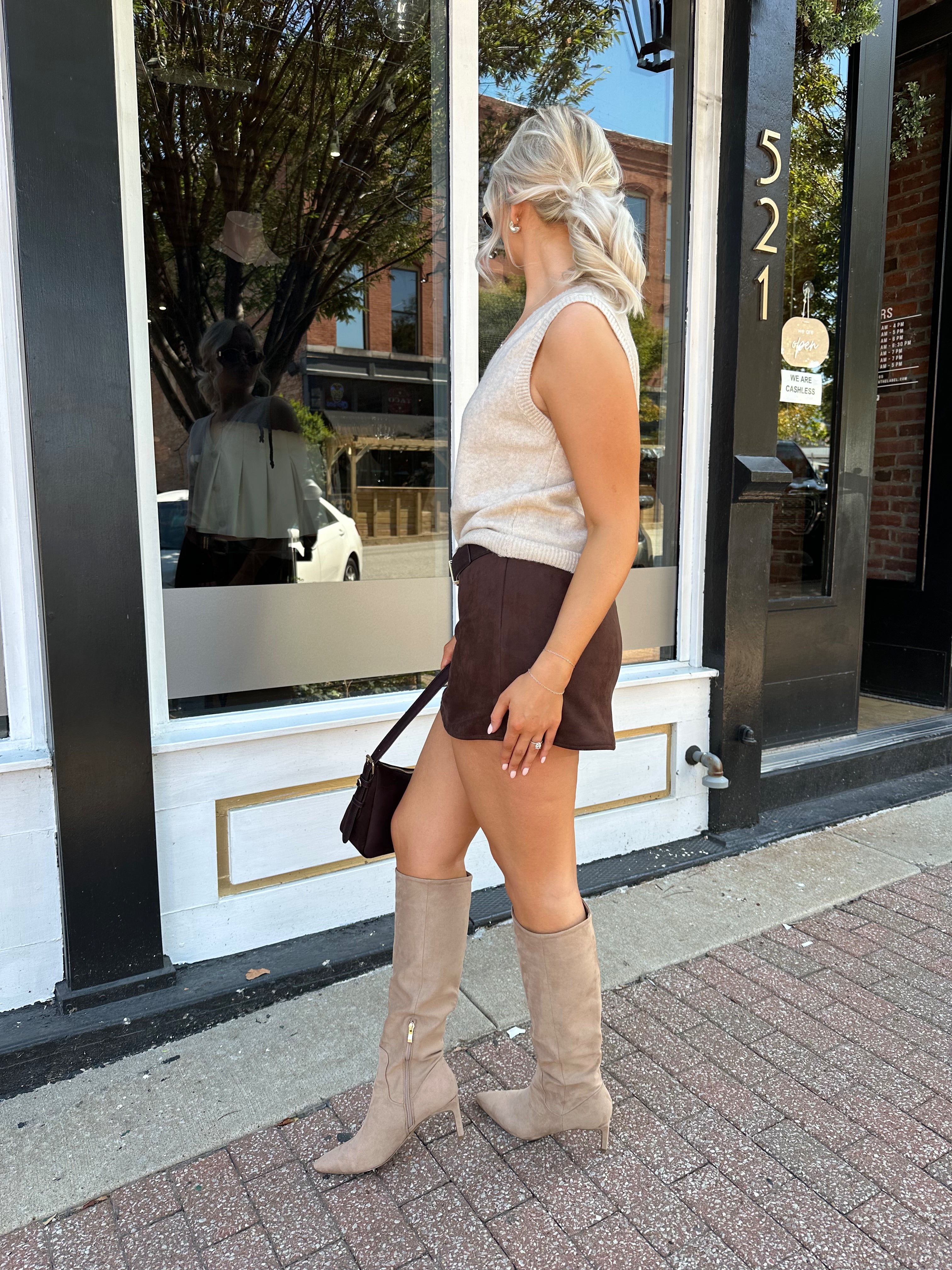 Woman wearing dark brown suede mini skirt with built in shorts. 