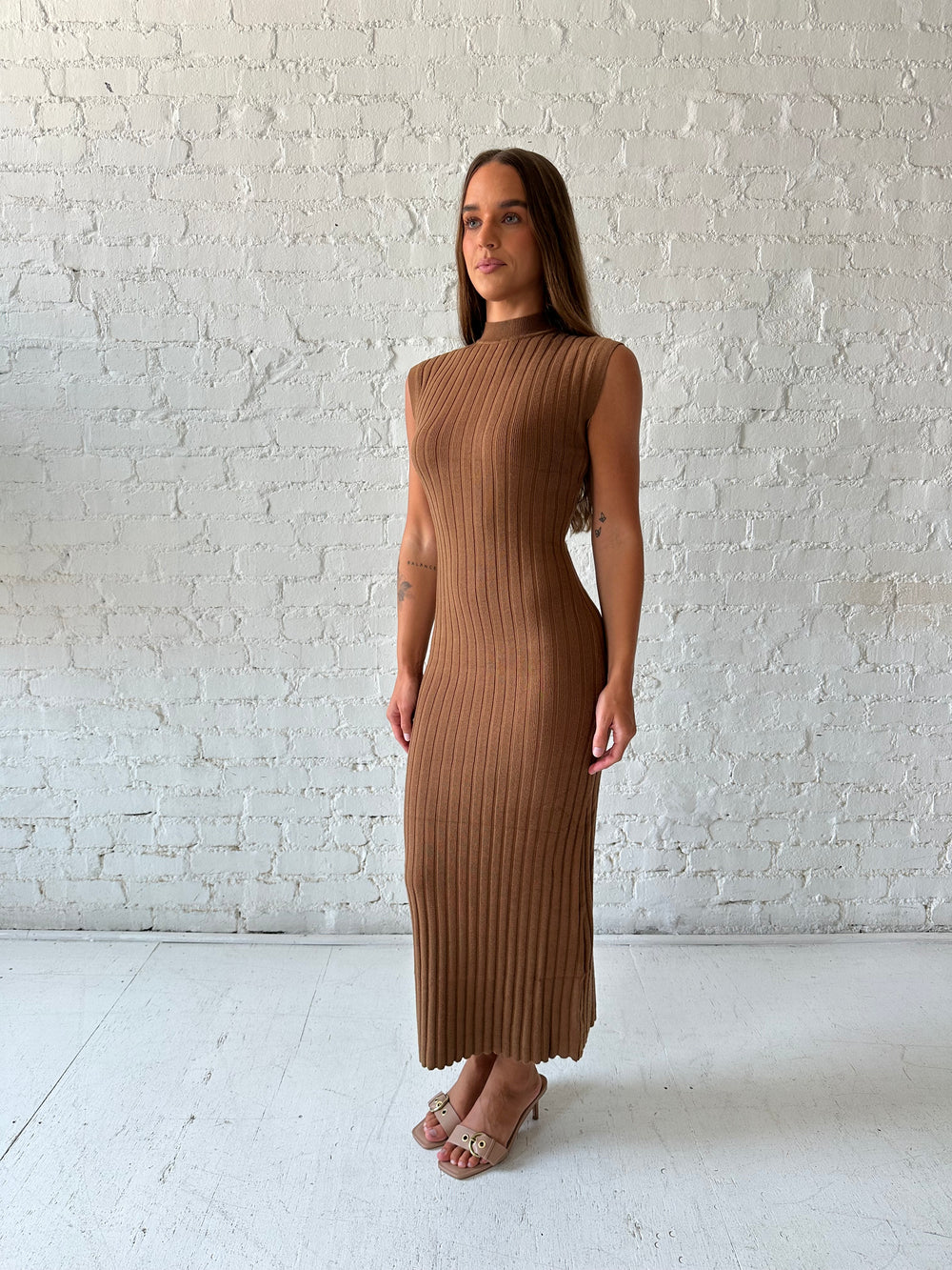 Woman wearing brown knit midi dress with high neckline.