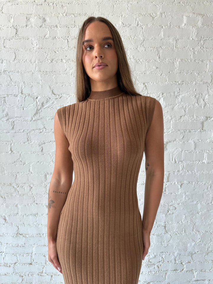 Woman wearing brown knit midi dress with high neckline.