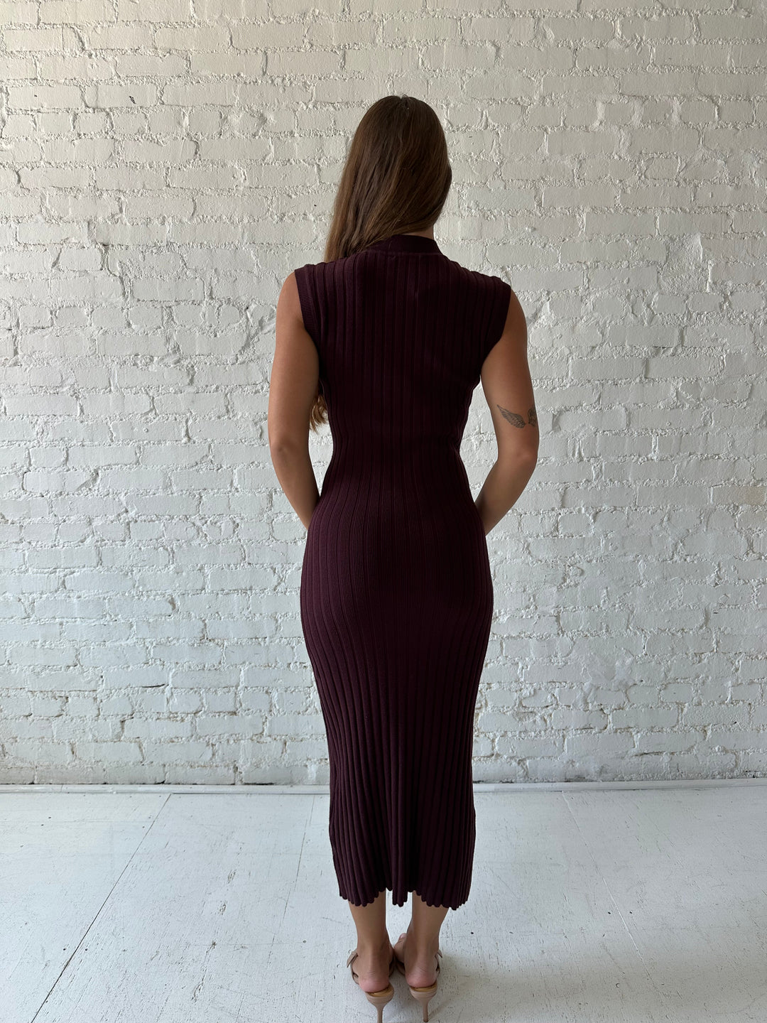 Woman wearing a burgundy knit midi dress with high neckline.