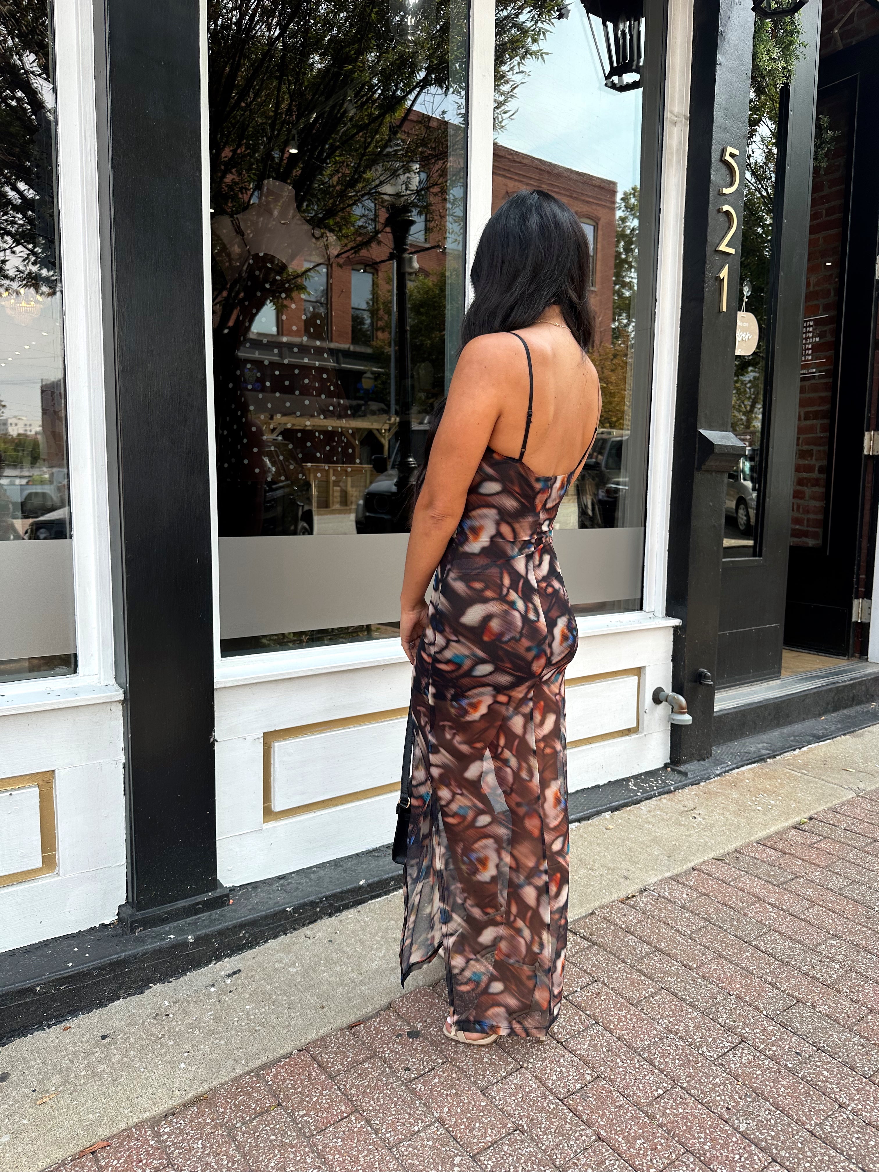 Woman wearing black multi color floral mesh bodycon maxi dress. 