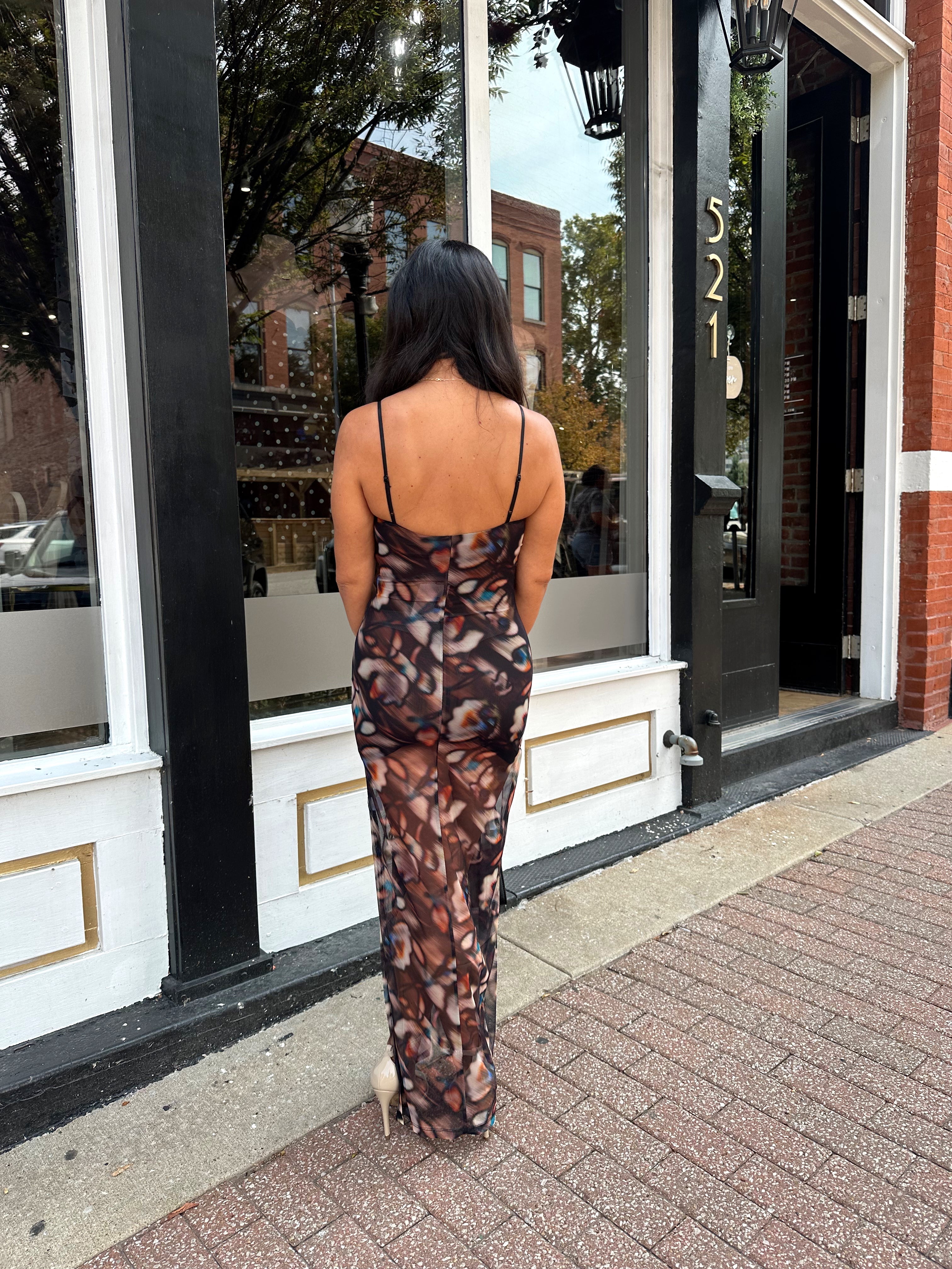 Woman wearing black multi color floral mesh bodycon maxi dress. 