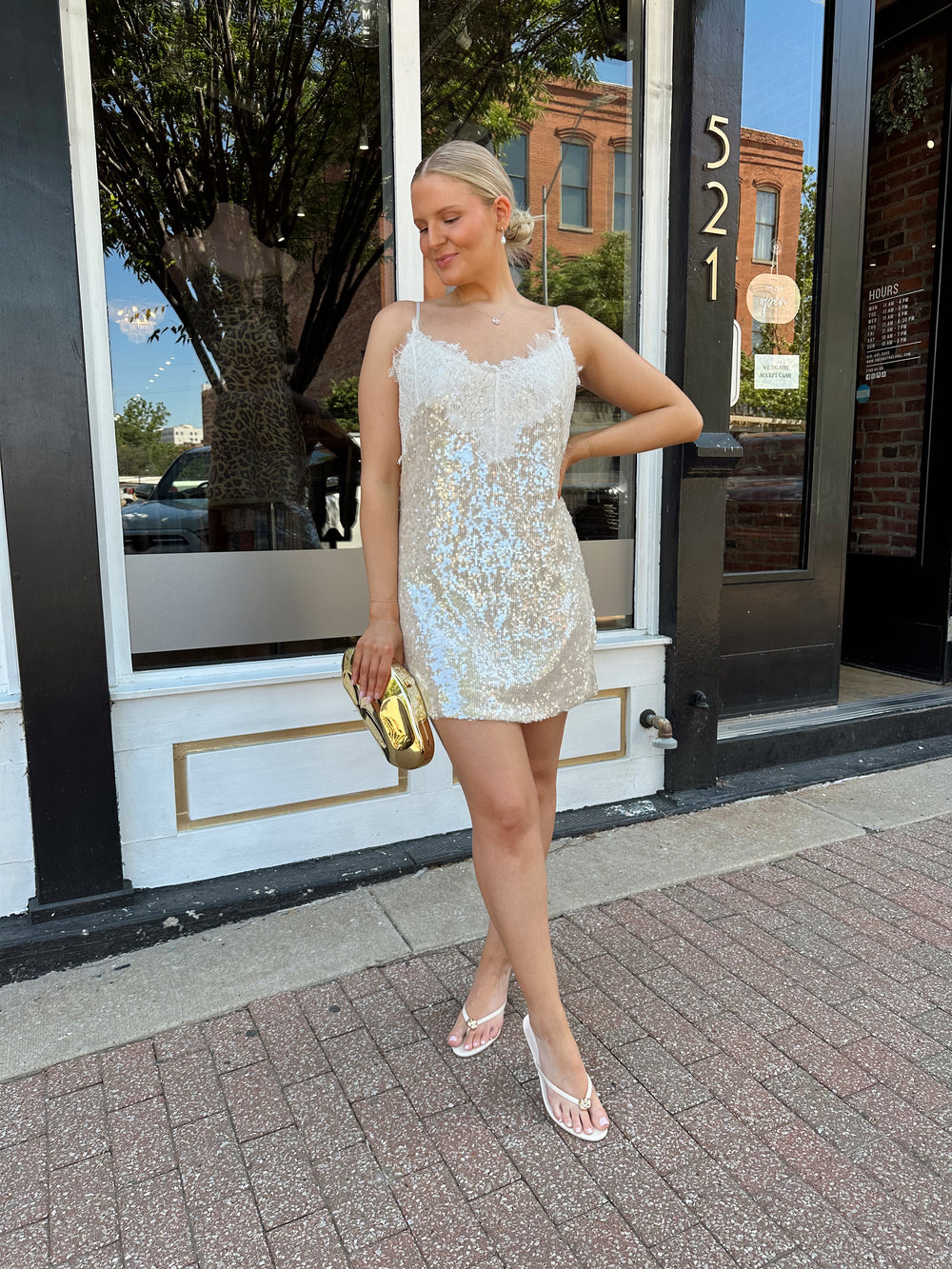 Woman wearing yellow sequin shift dress with lace trim neckline, and adjustable spaghetti traps.