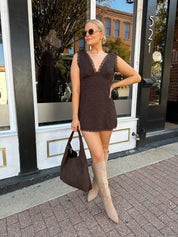 Model wearing brown eyelet lace mini dress with open back and scalloped trim.