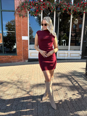 Woman wearing burgundy knit mock neck mini dress with leather trench coat.