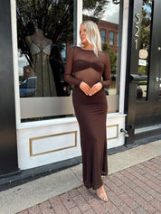 Woman wearing a long sleeve brown sheer maxi dress.