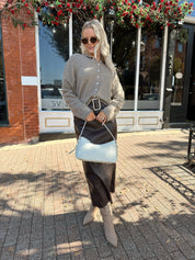 Woman wearing dark brown belted leather midi skirt with mocha knit cardigan.