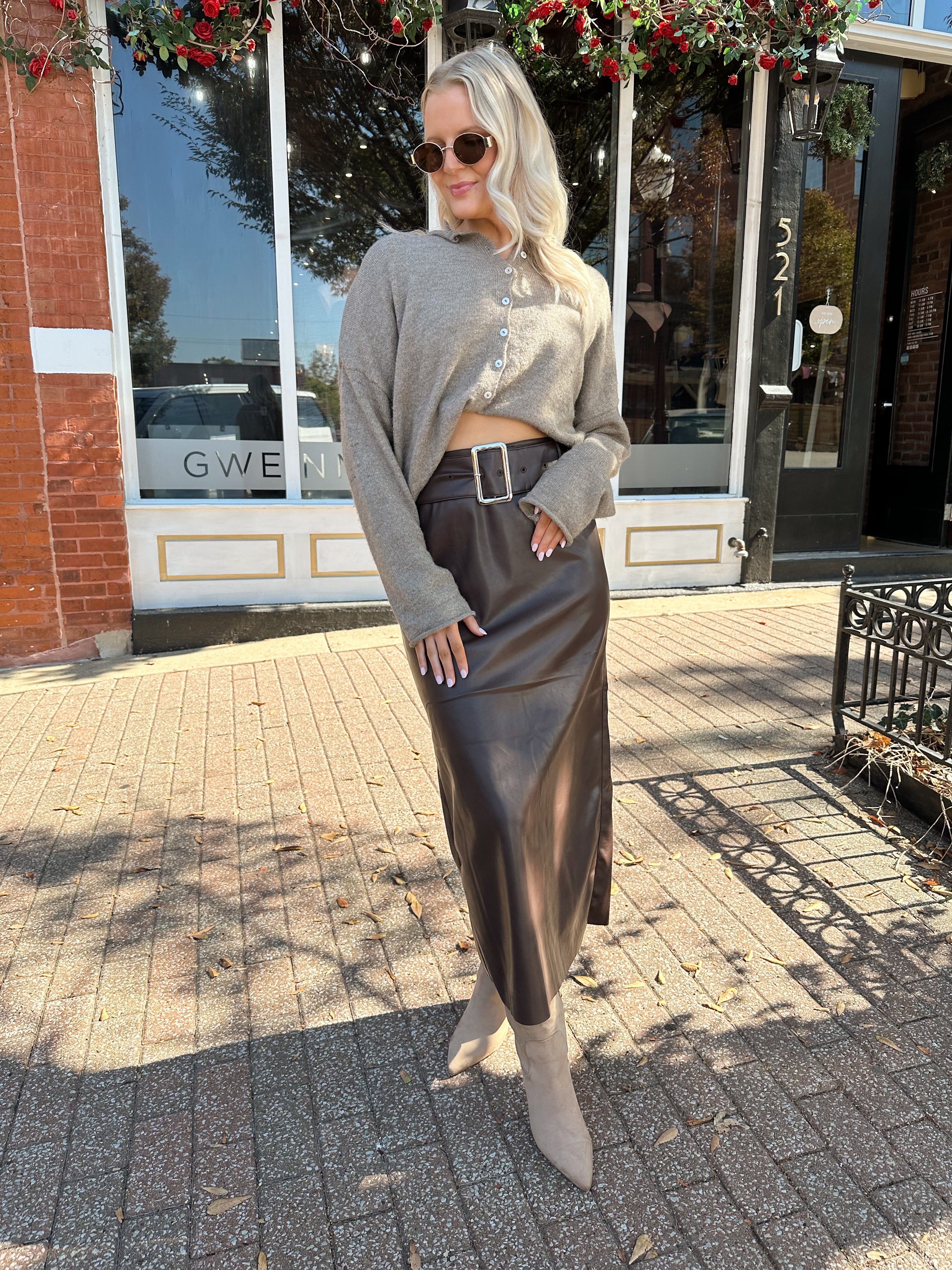 Woman wearing dark brown belted leather midi skirt with mocha knit cardigan.