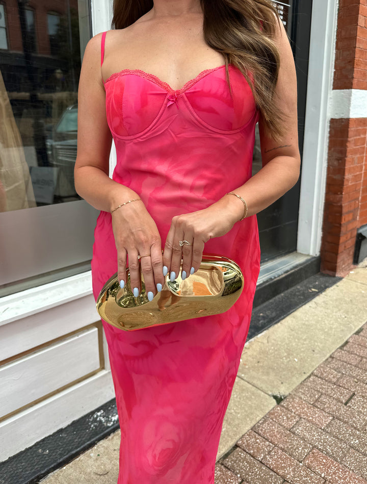 Woman wearing hot pink floral maxi dress with adjustable spaghetti straps and bustier bodice. 