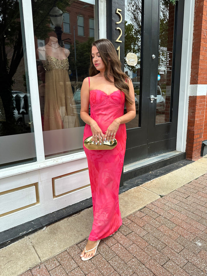 Woman wearing hot pink floral maxi dress with adjustable spaghetti straps and bustier bodice. 