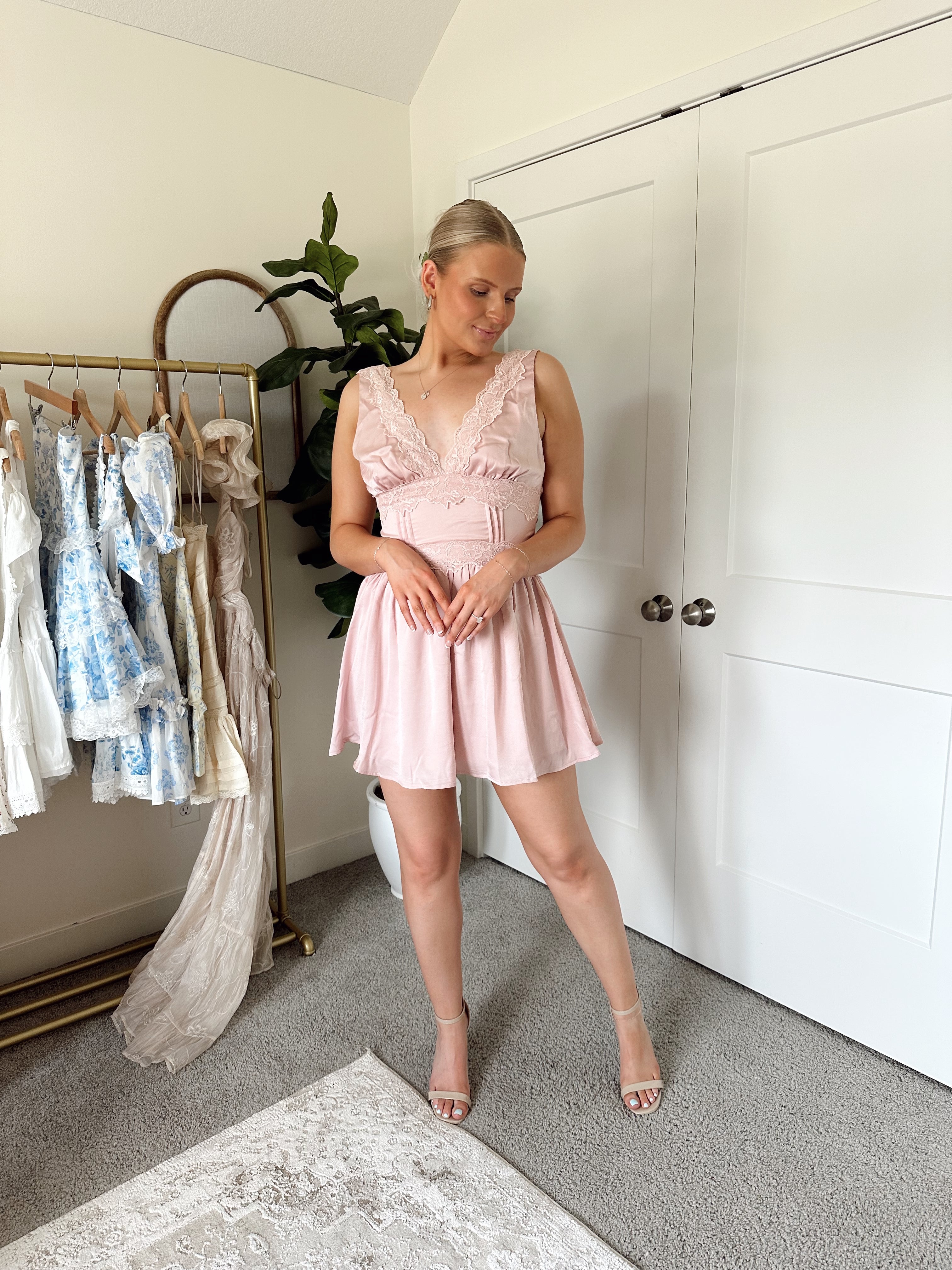 Pink satin mini dress with lace trim, v-neckline, and corset-style waist