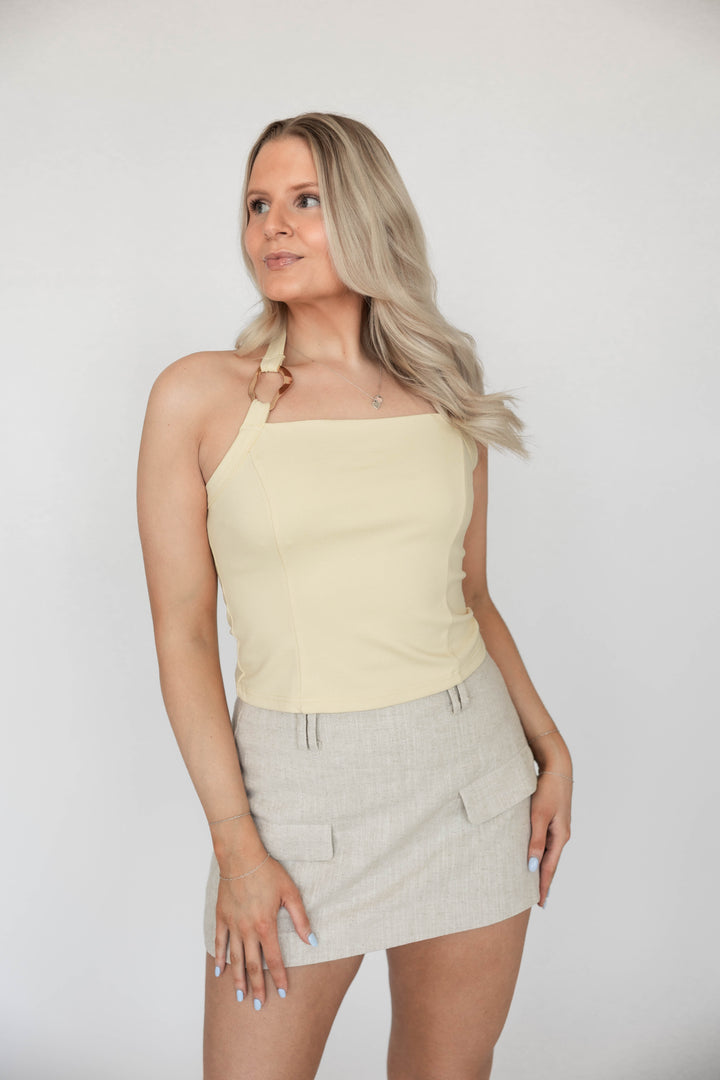 Woman wearing neutral linen mini skort with a yellow top.