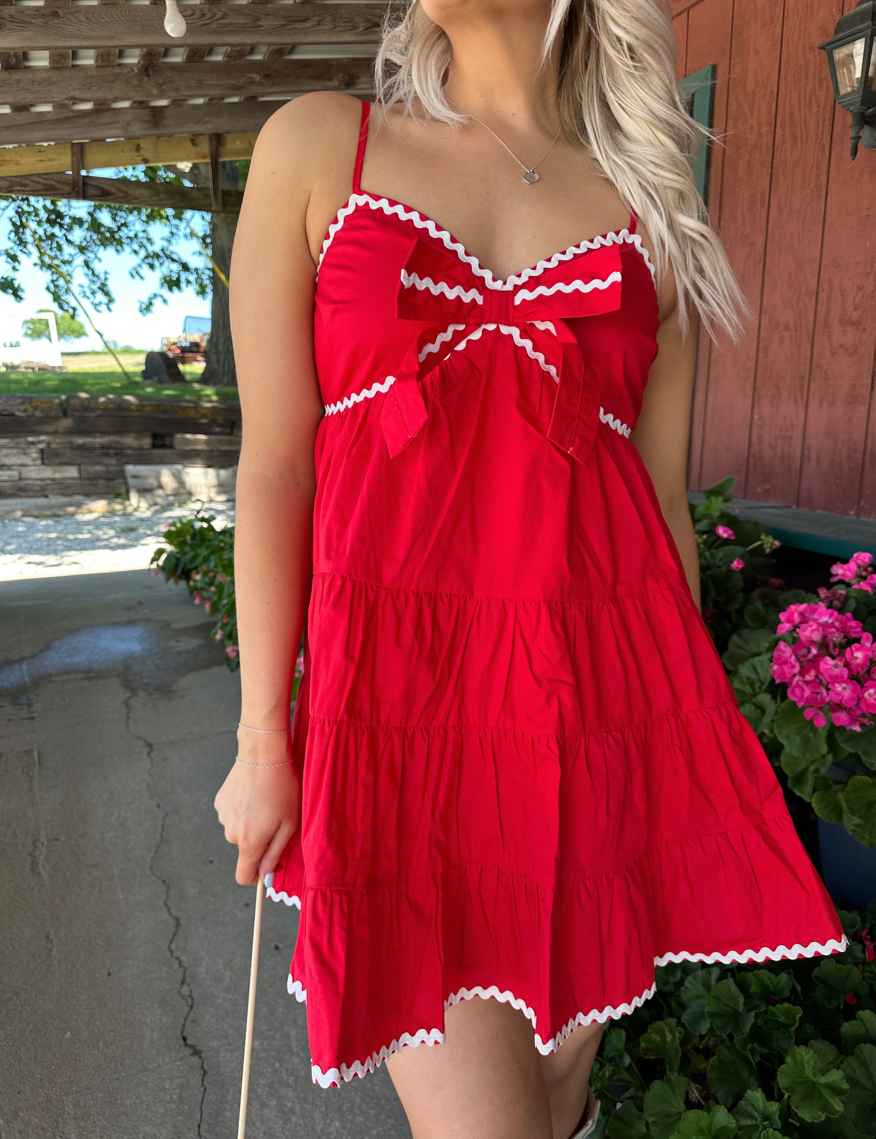 Red tiered mini dress with white lining detail. Adjustable spaghetti straps.