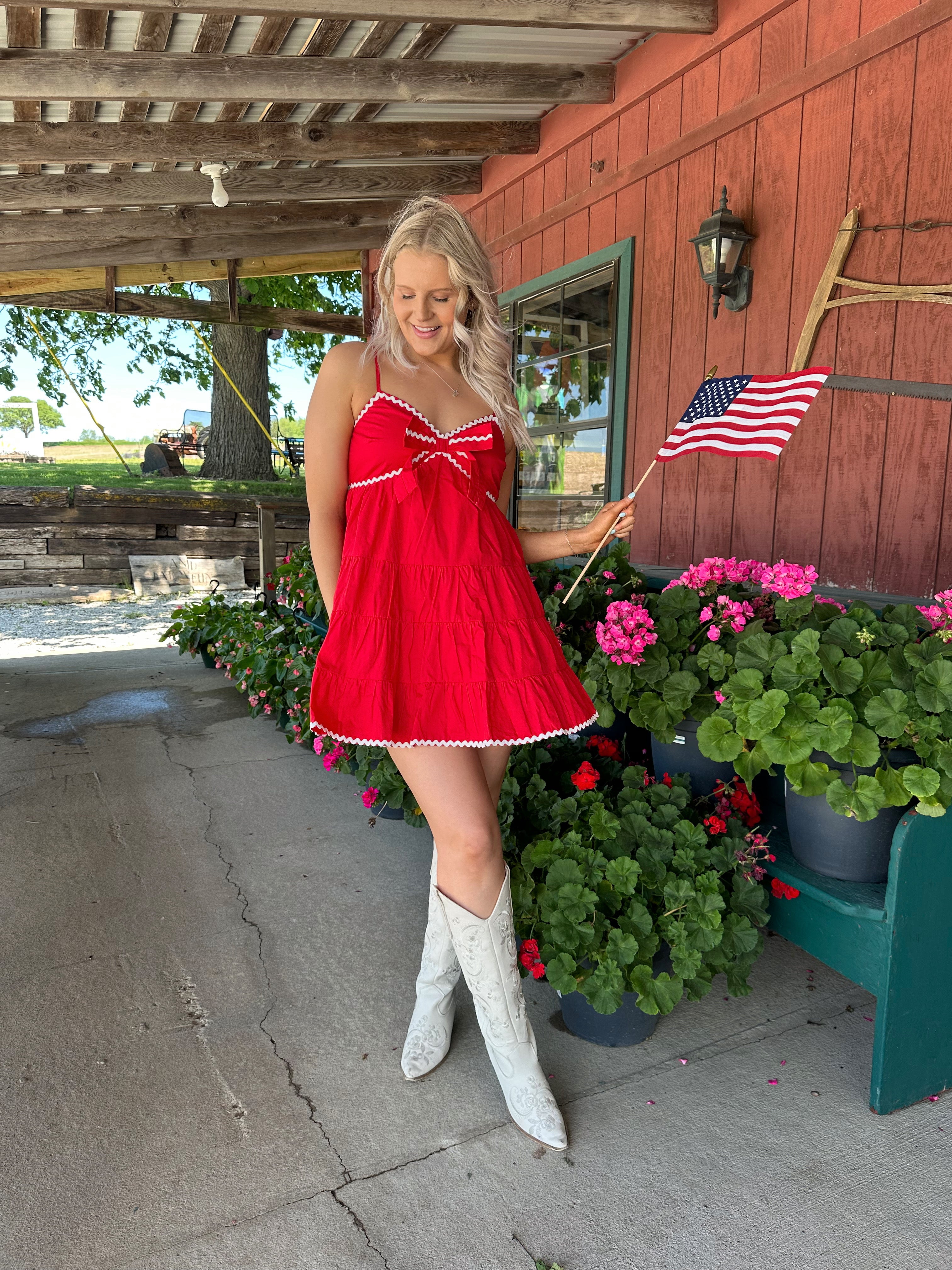 Red tiered mini dress with white lining detail. Adjustable spaghetti straps.