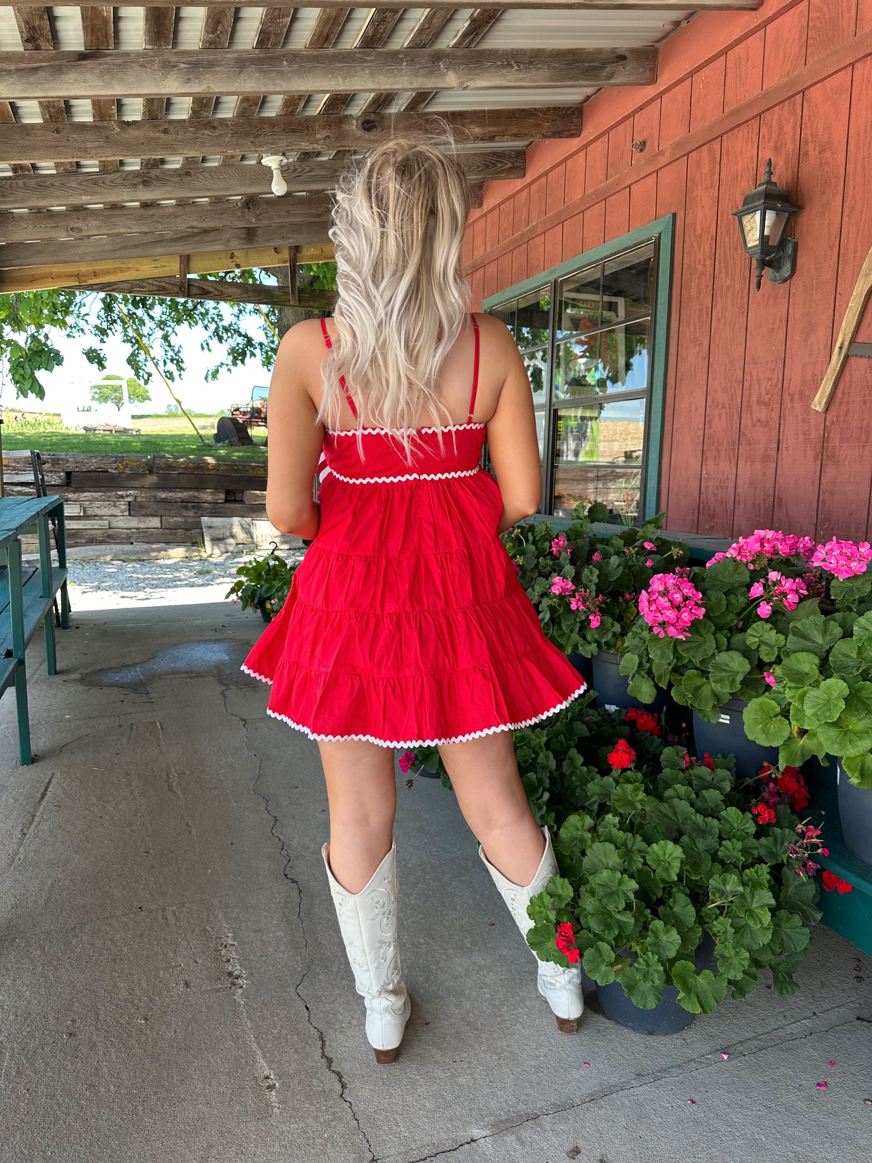 Red tiered mini dress with white lining detail. Adjustable spaghetti straps.