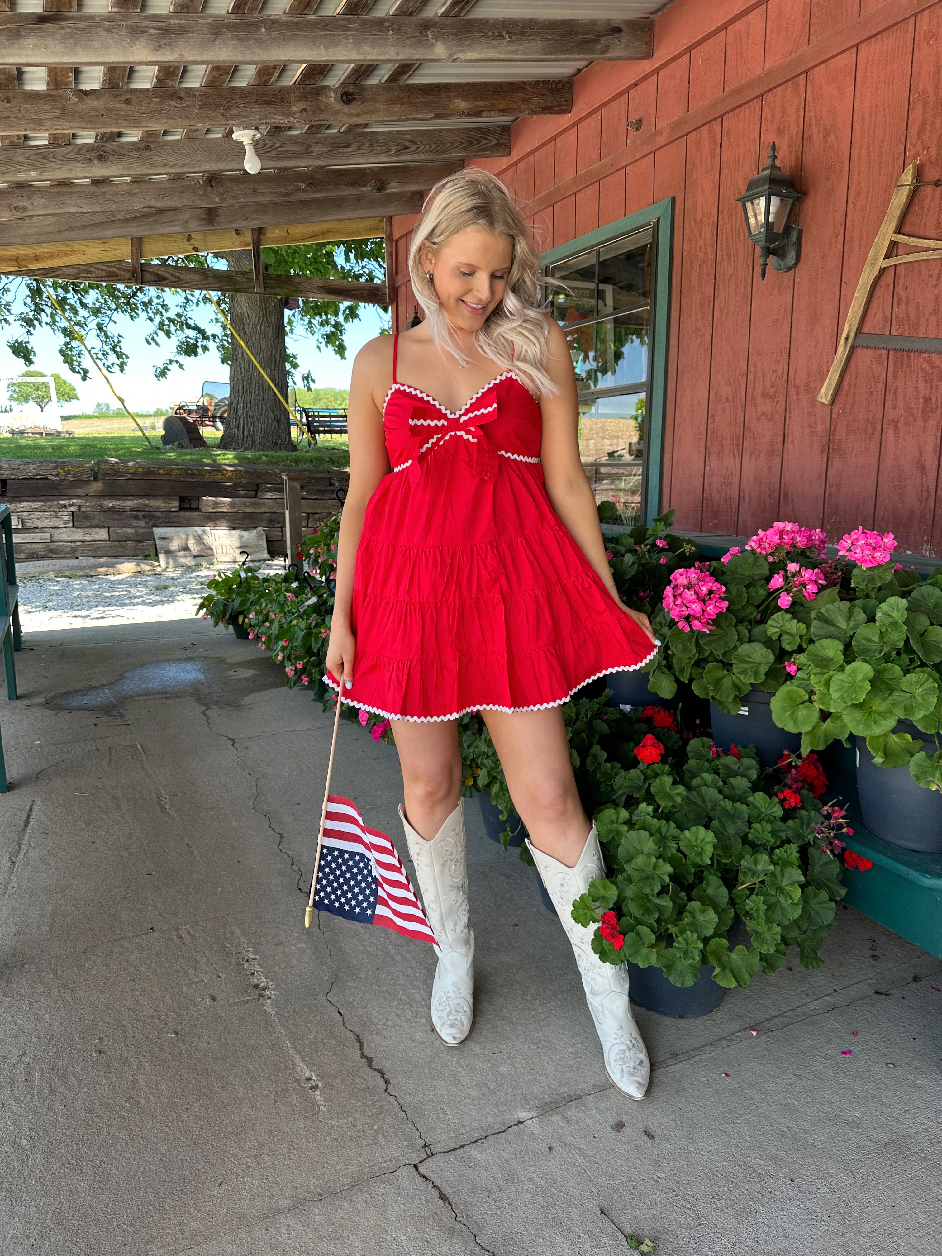 Red tiered mini dress with white lining detail. Adjustable spaghetti straps.