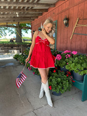 Red tiered mini dress with white lining detail. Adjustable spaghetti straps.