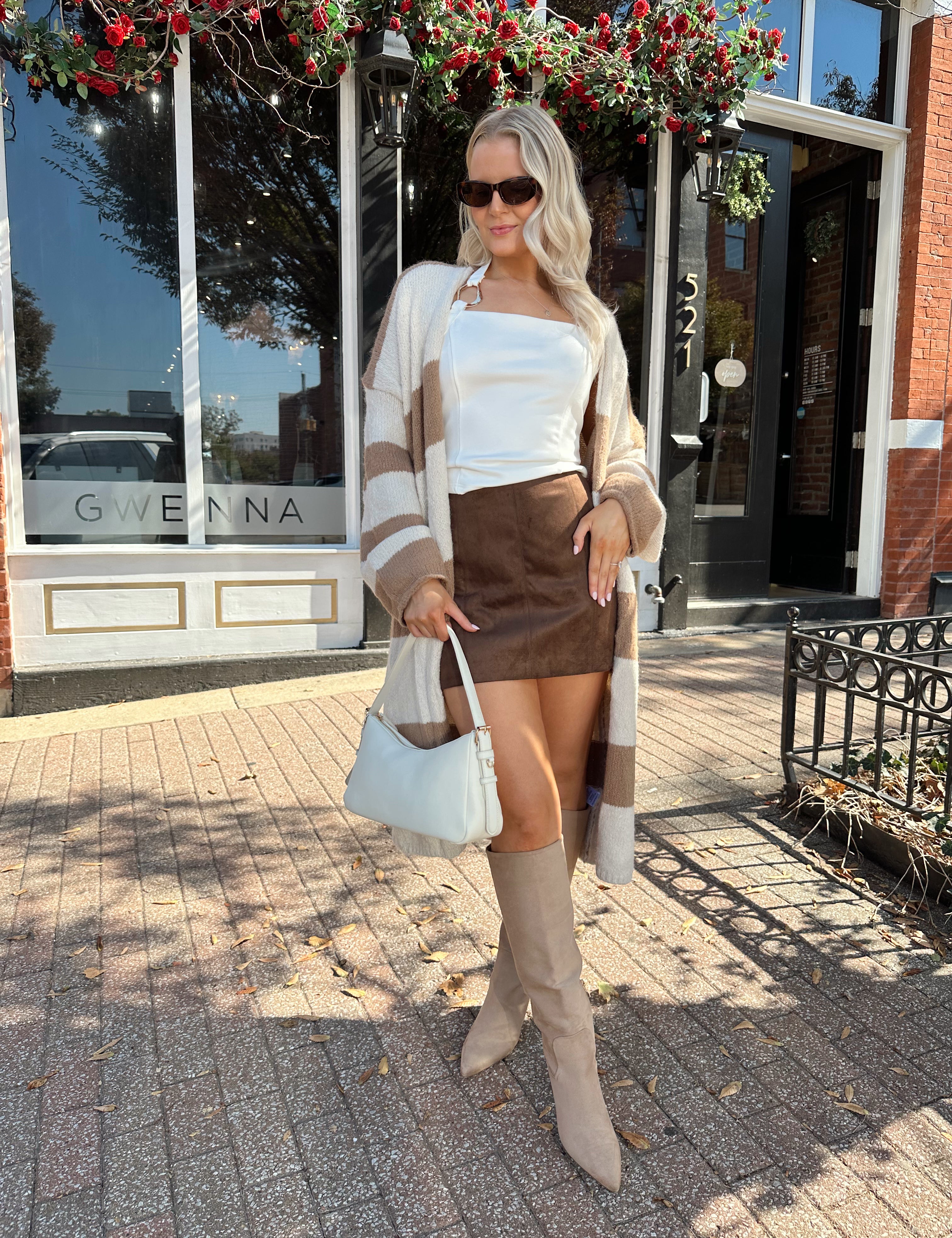 Woman wearing brown and cream striped cardigan with functional pockets.