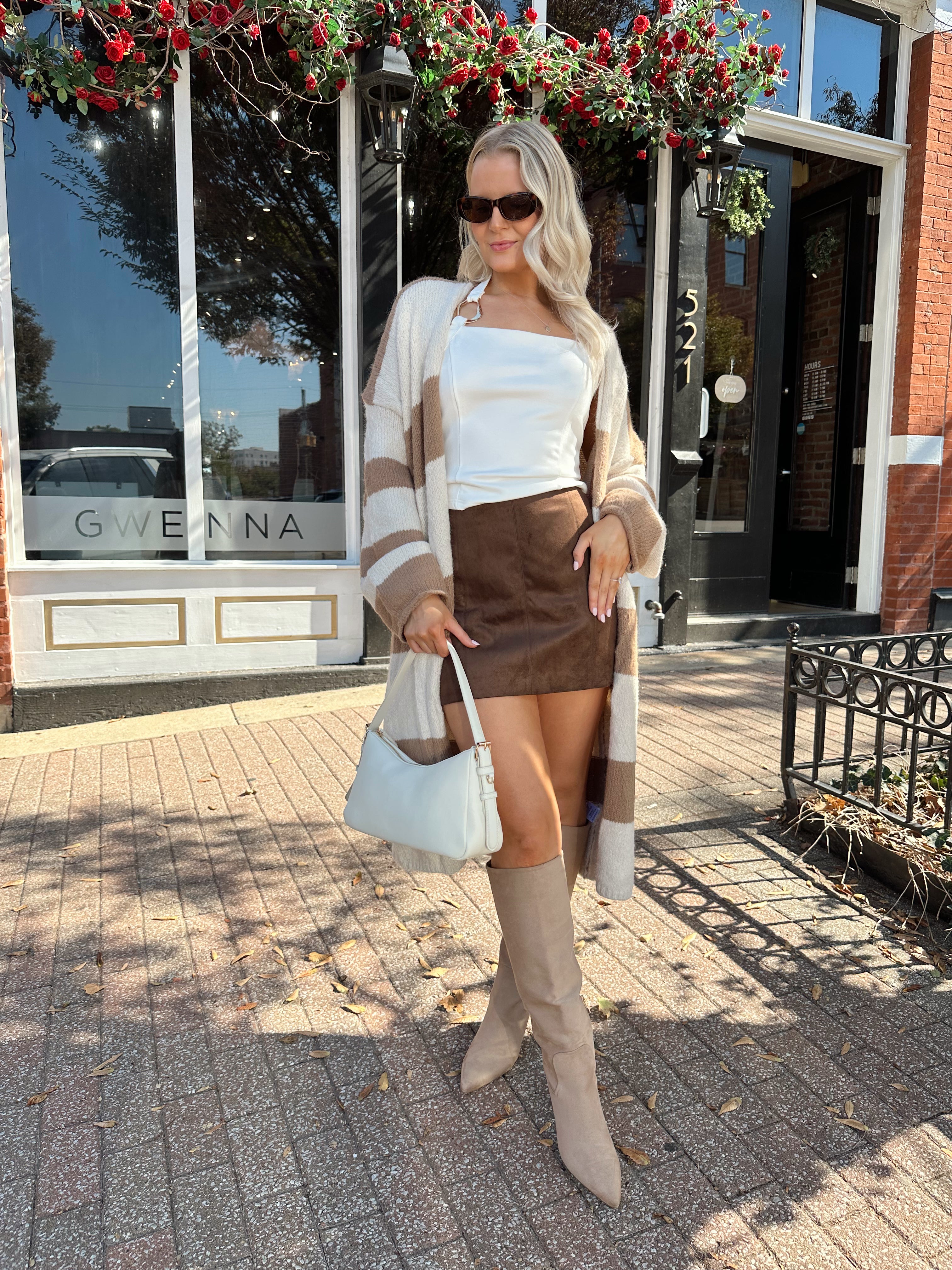 Woman wearing brown and cream striped cardigan with functional pockets.