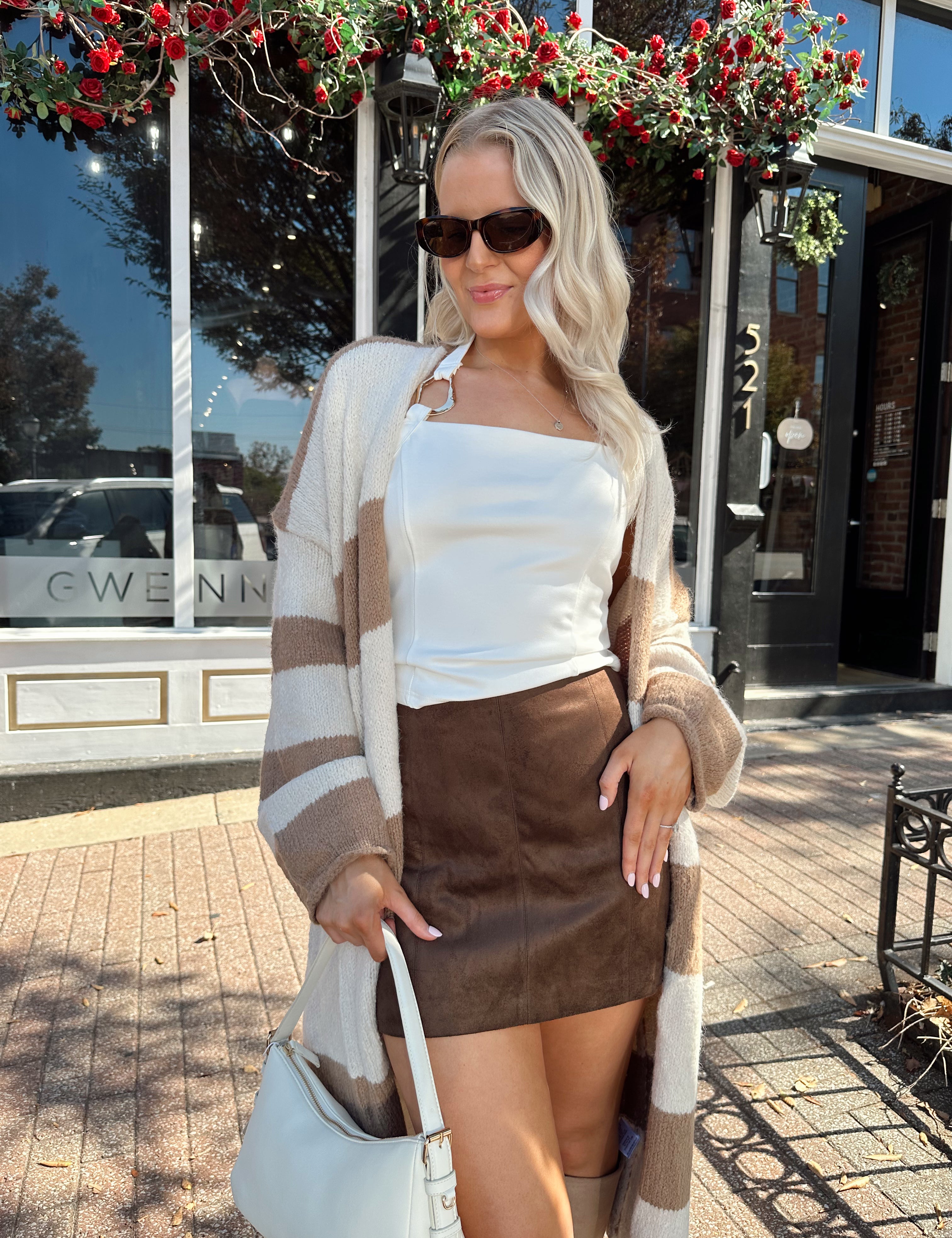 Woman wearing brown and cream striped cardigan with functional pockets.