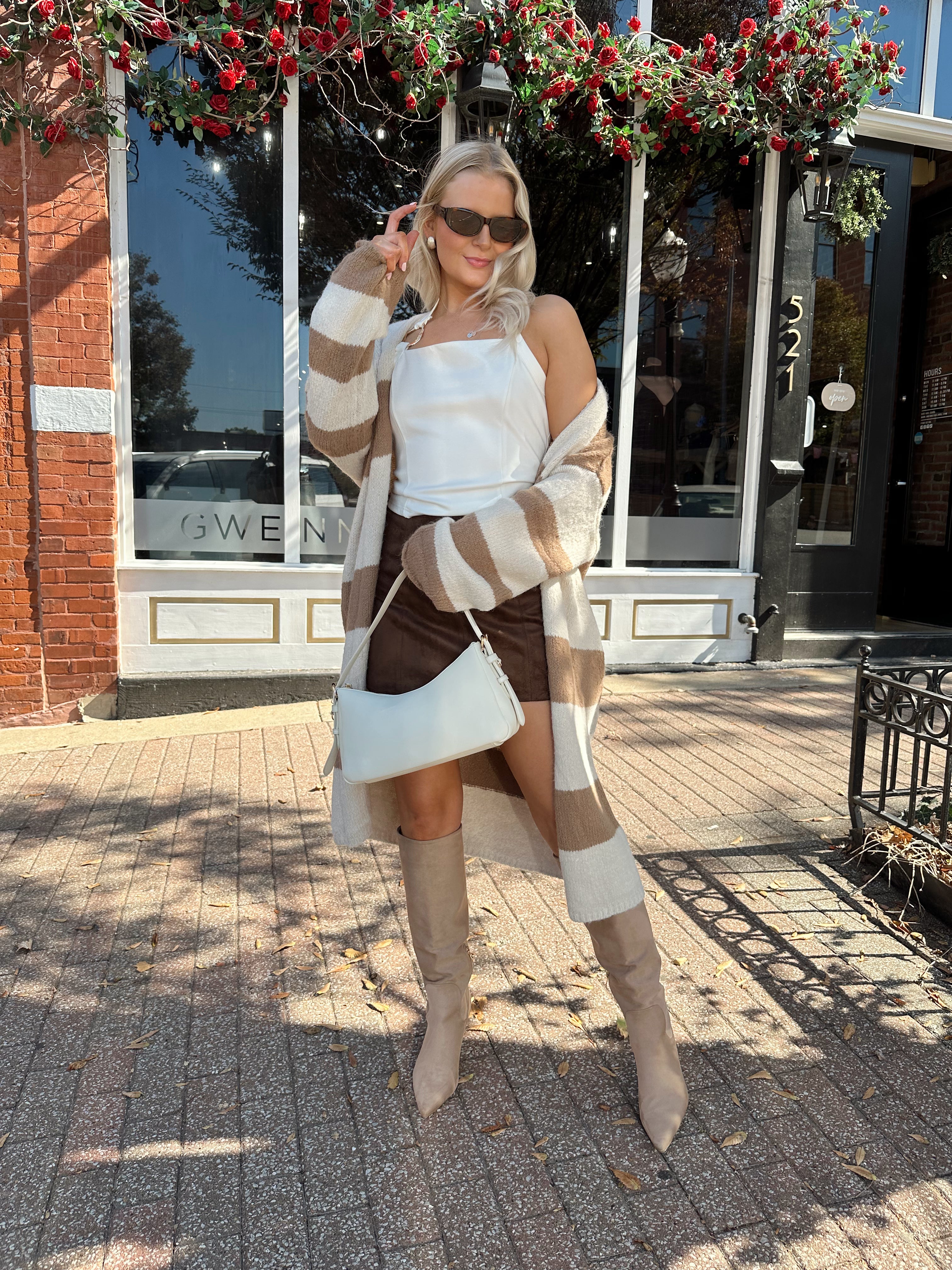 Woman wearing brown and cream striped cardigan with functional pockets.