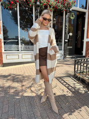 Woman wearing brown and cream striped cardigan with functional pockets.