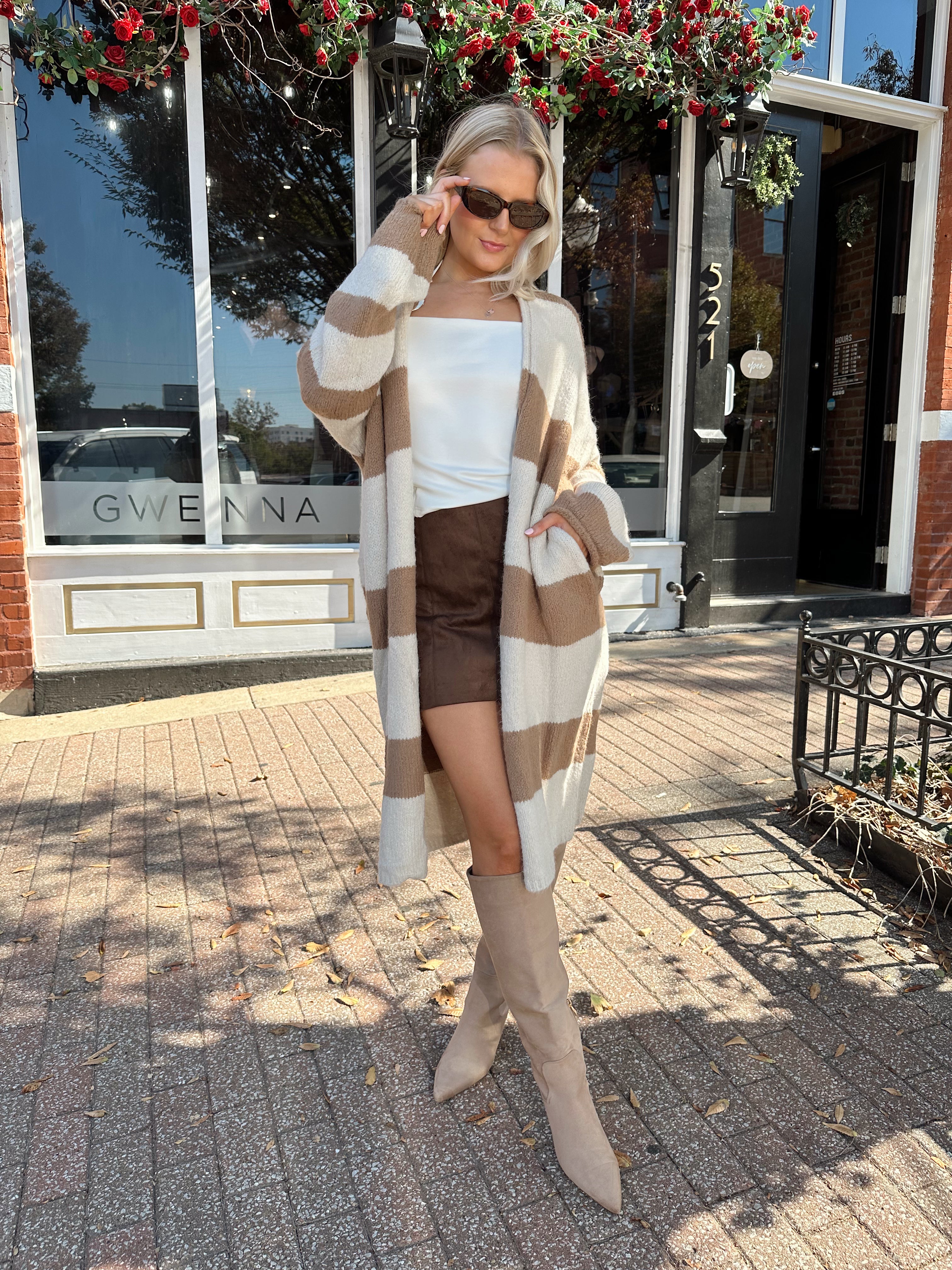 Woman wearing brown and cream striped cardigan with functional pockets.