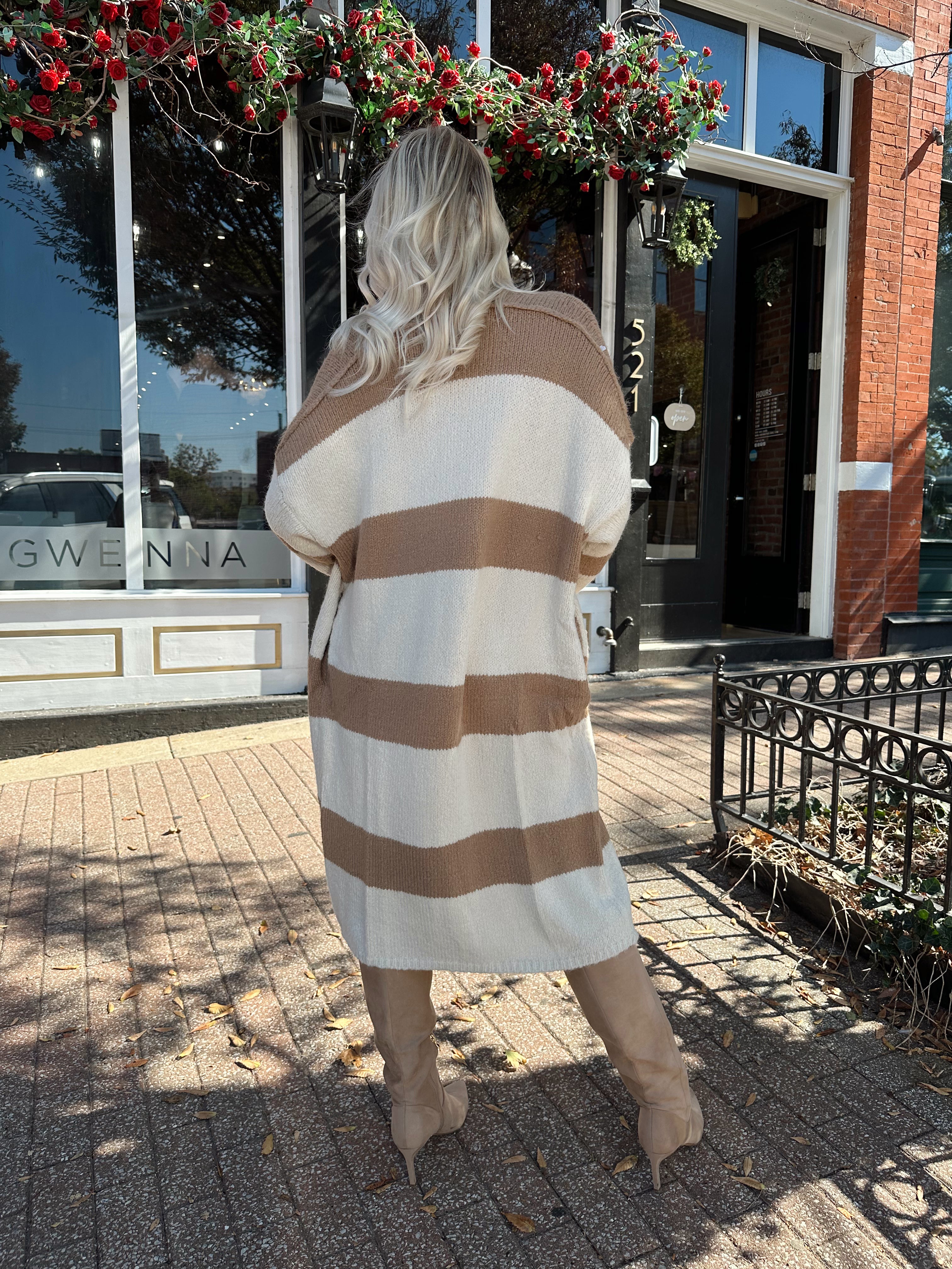 Woman wearing brown and cream striped cardigan with functional pockets.