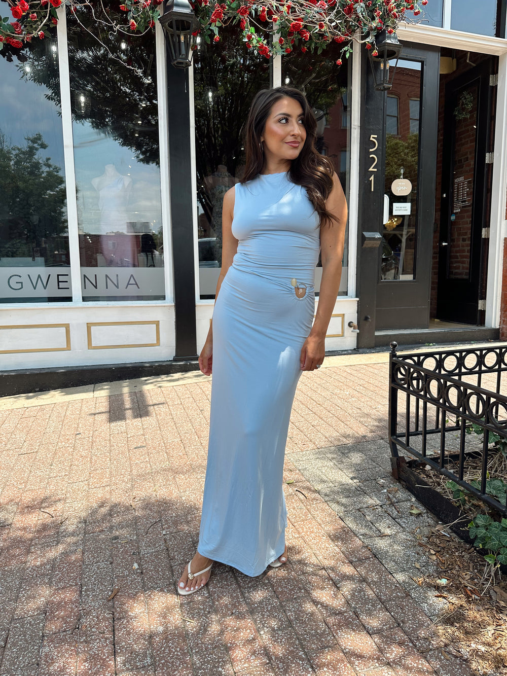 Woman wearing soft light blue two piece maxi skirt set with ring and bead detailing. 