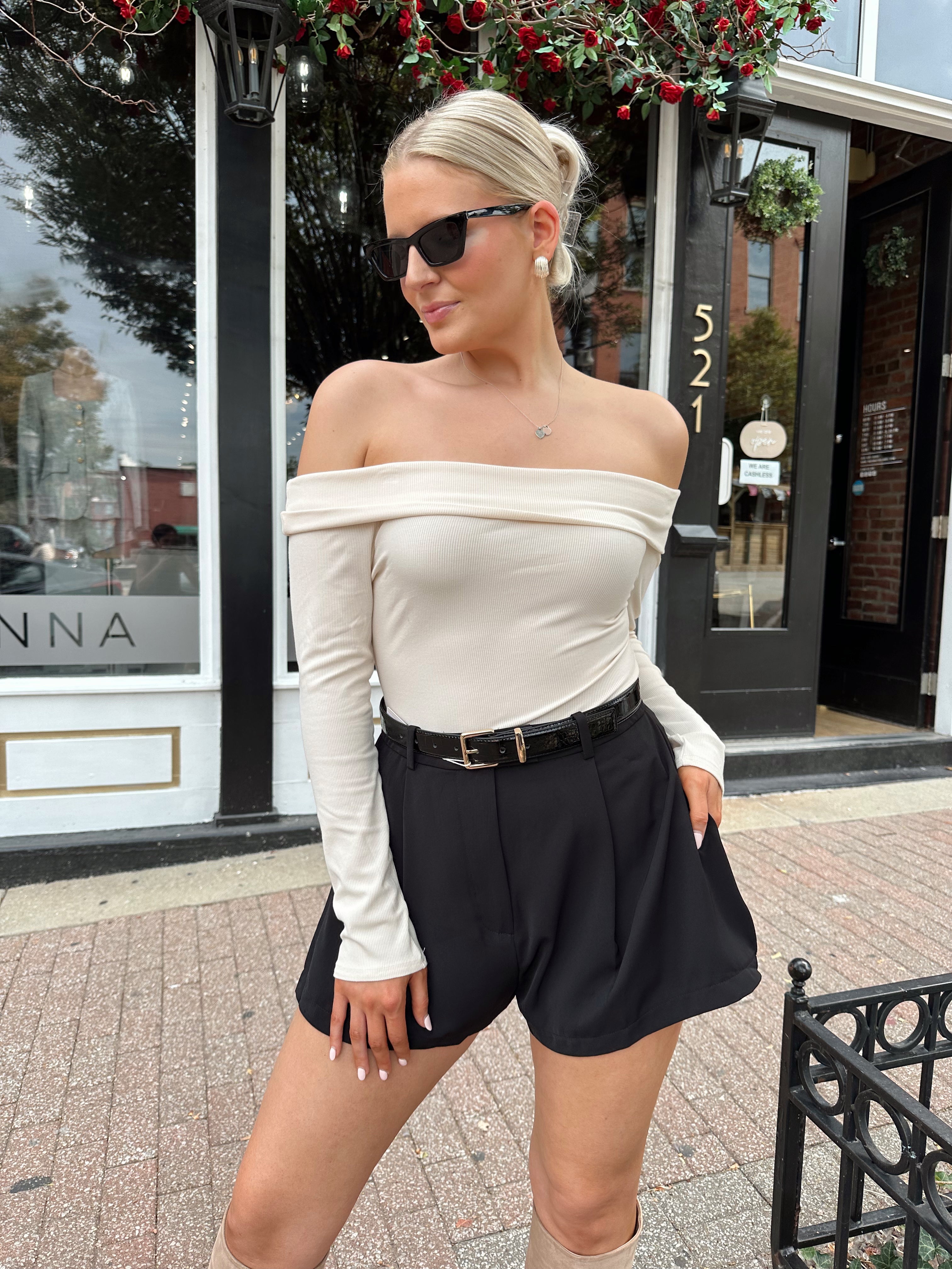 Black tailored short with functional pockets and sleek structured silhouette