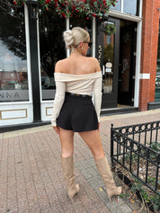 Black tailored short with functional pockets and sleek structured silhouette