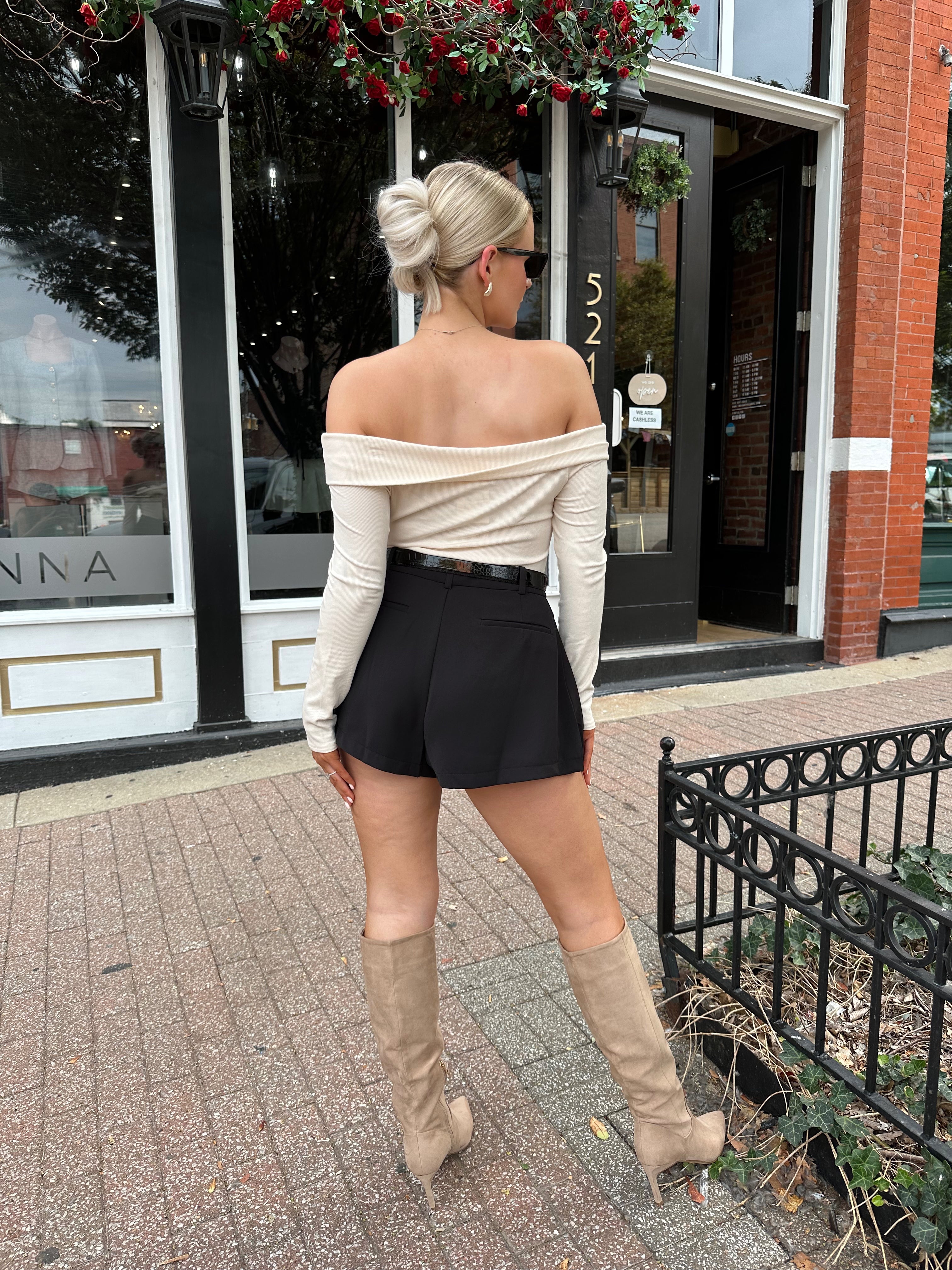 Black tailored short with functional pockets and sleek structured silhouette
