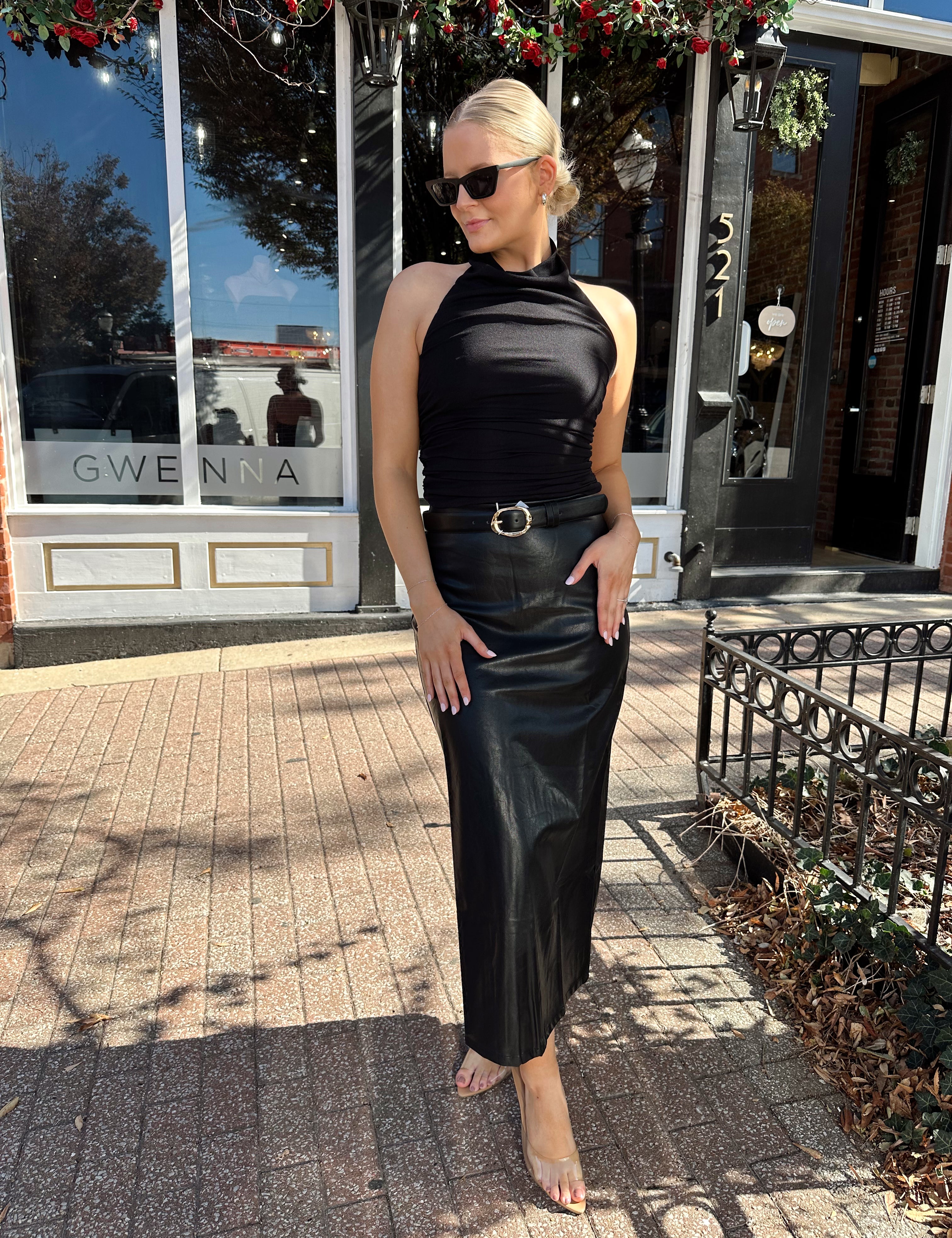 Woman wearing black mesh cowl, halter neck top.