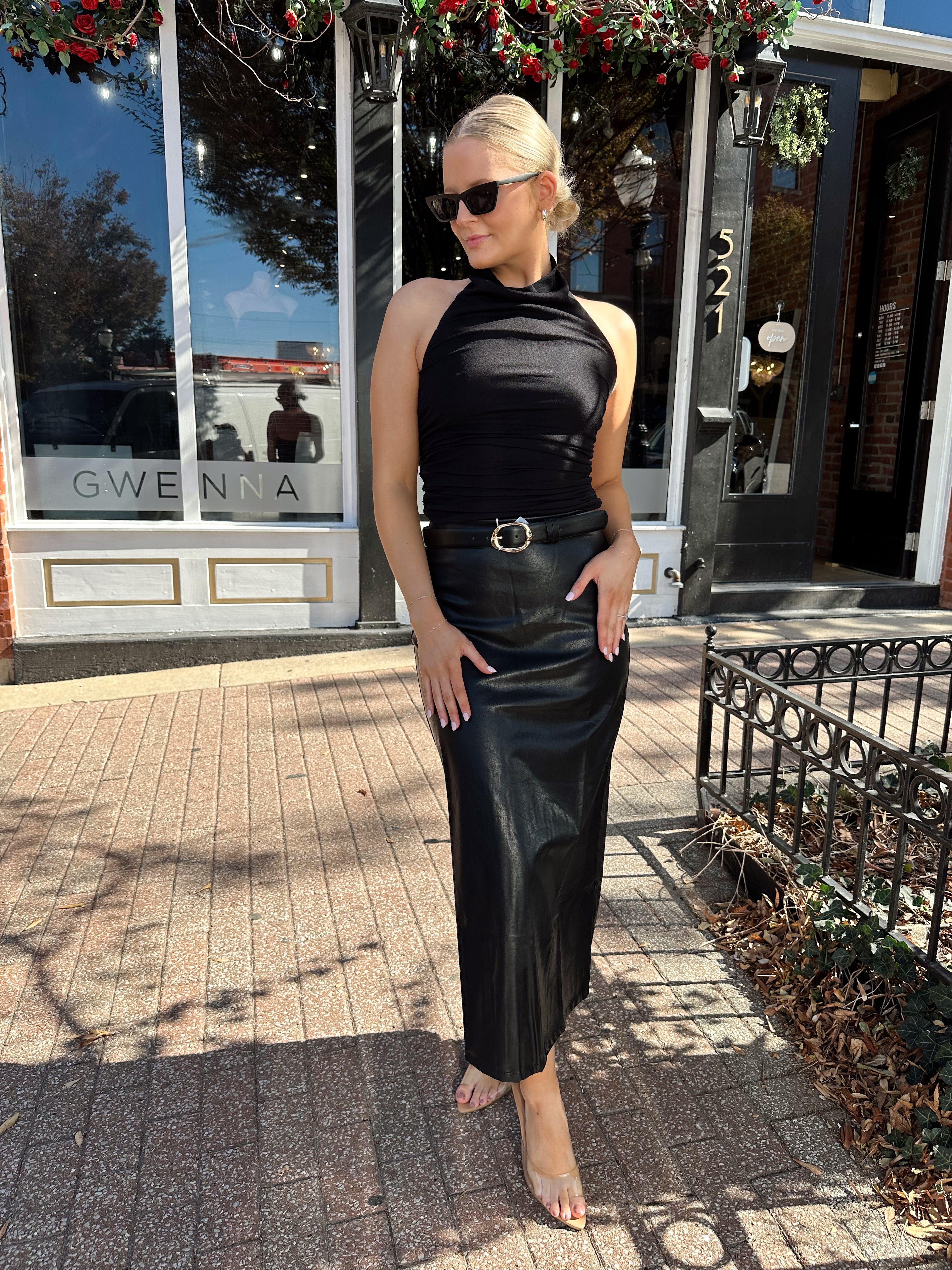 Woman wearing black mesh cowl, halter neck top.