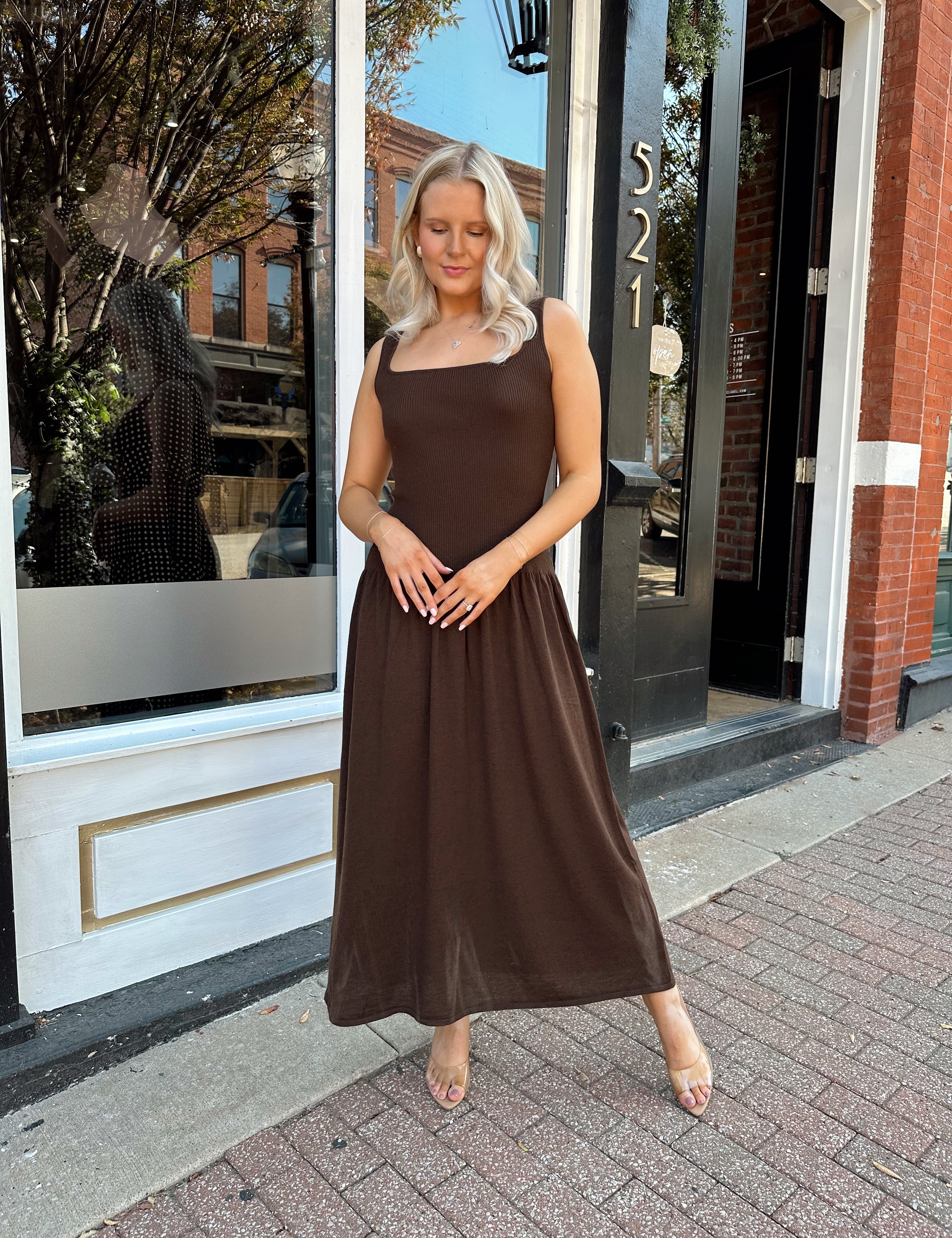 Woman wearing brown knit drop waist maxi dress with scoop neckline. 