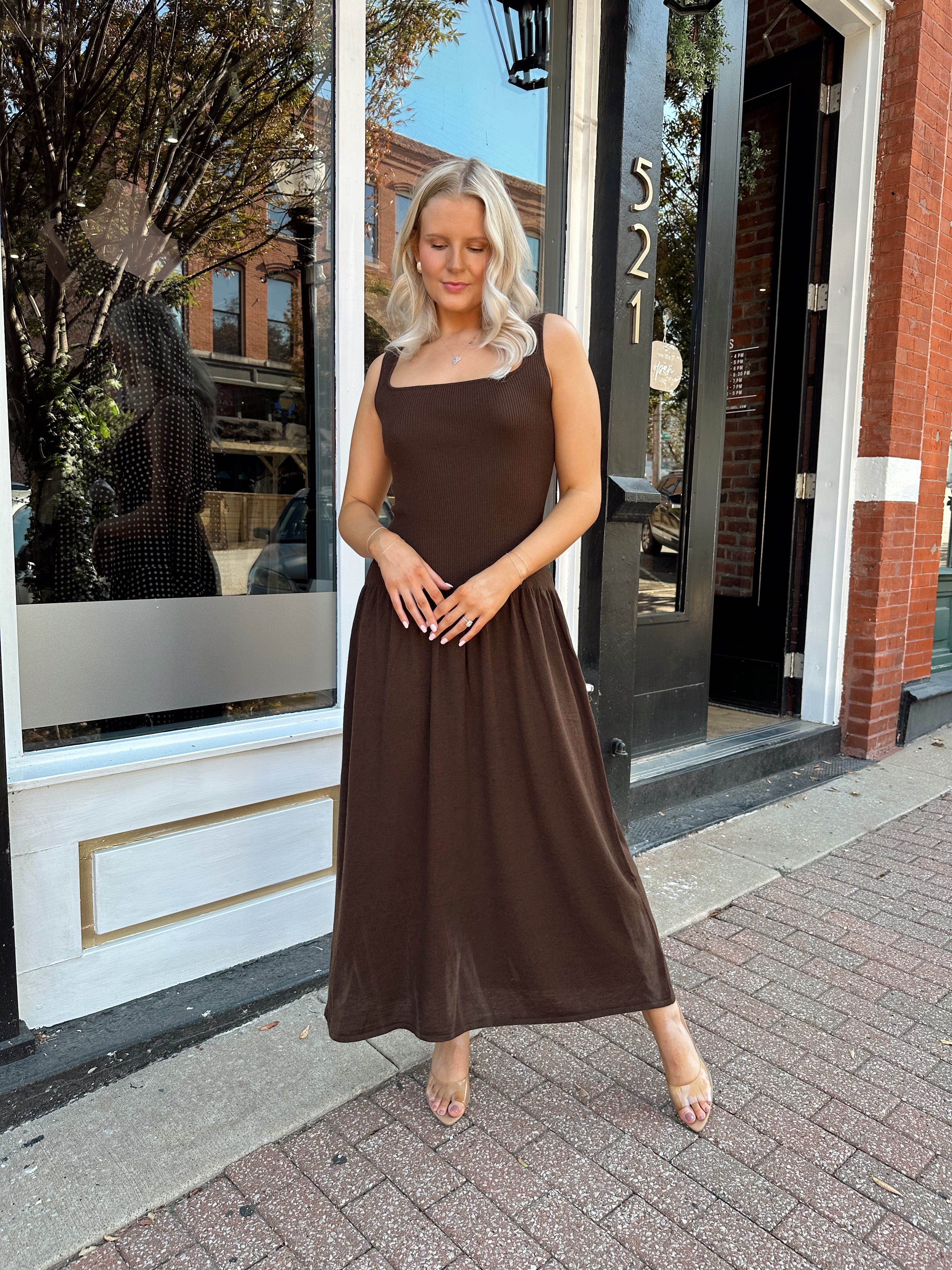 Woman wearing brown knit drop waist maxi dress with scoop neckline. 
