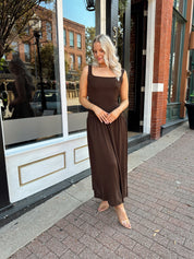 Woman wearing brown knit drop waist maxi dress with scoop neckline. 